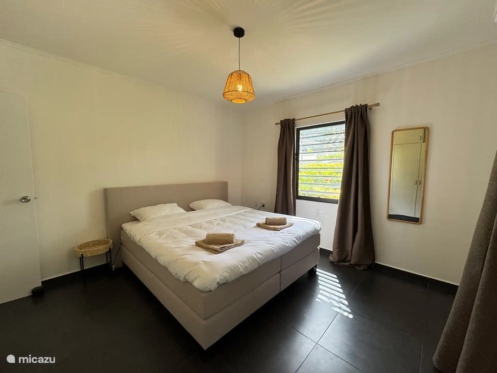 Grande chambre avec lit boxspring king-size de haute qualité (180x200) avec une couette (240x210), climatisation, tables de chevet, miroir, panier à linge, placard avec penderie et pose et un coffre-fort.