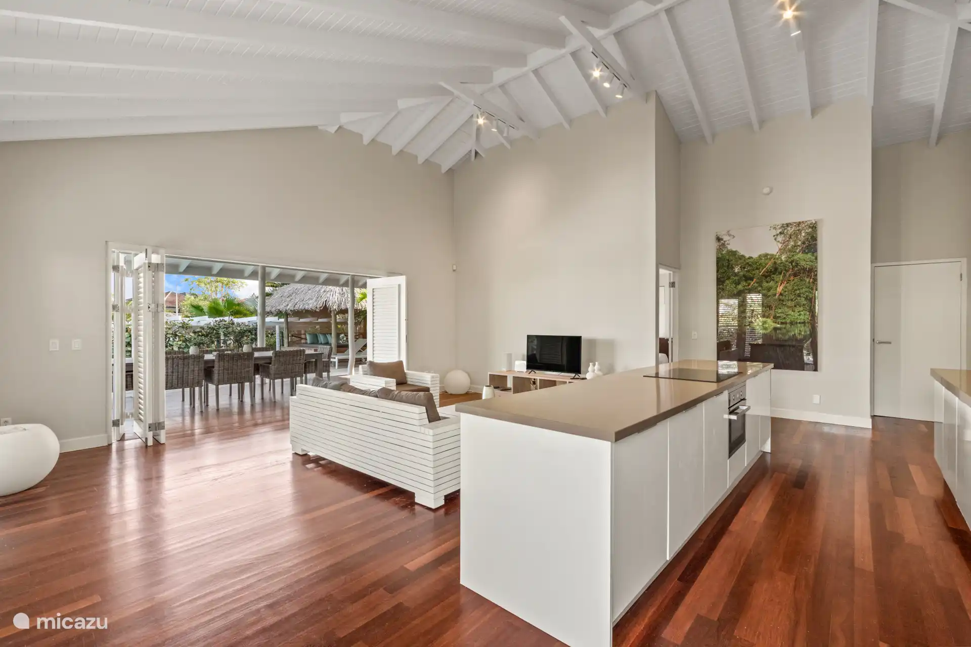 Geräumiges Wohnzimmer mit hohen Decken, gemütlicher Sitzecke und offener Küche