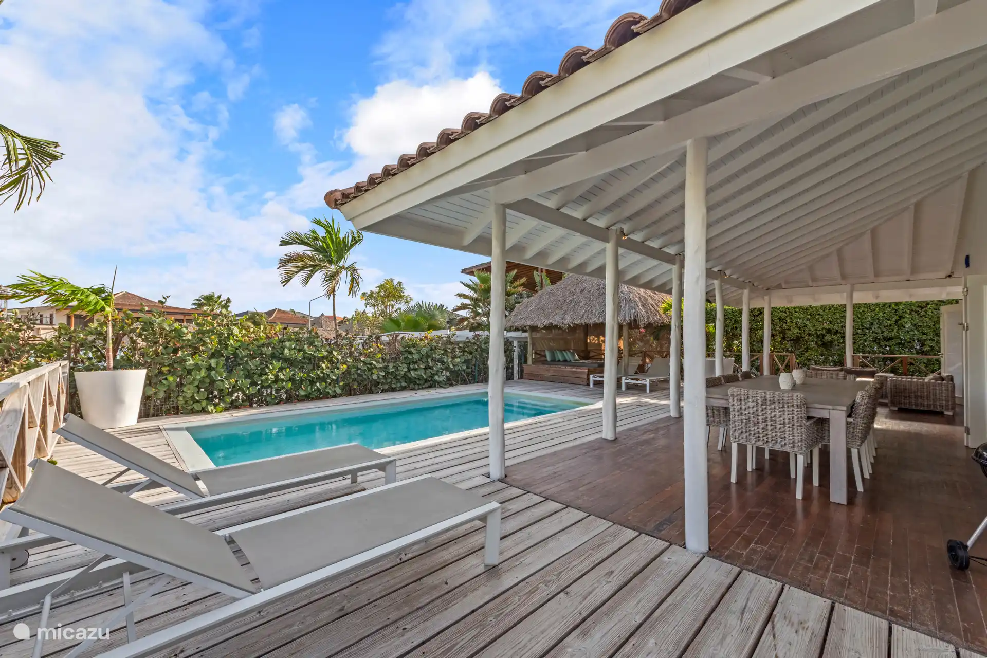 Wenn Sie in den Garten fahren, treten Sie ins Paradies ein. Bunte Blumen, sich wiegende Palmen, ein Swimmingpool mit Sonnenliegen, eine Palapa, ein schönes Lounge-Set und ein großer Esstisch draußen unter dem Rand