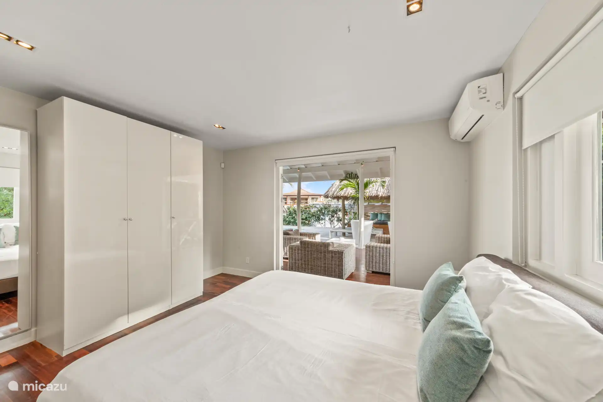 Schlafzimmer mit Klimaanlage, Kleiderschrank und Schiebetüren zur Terrasse.