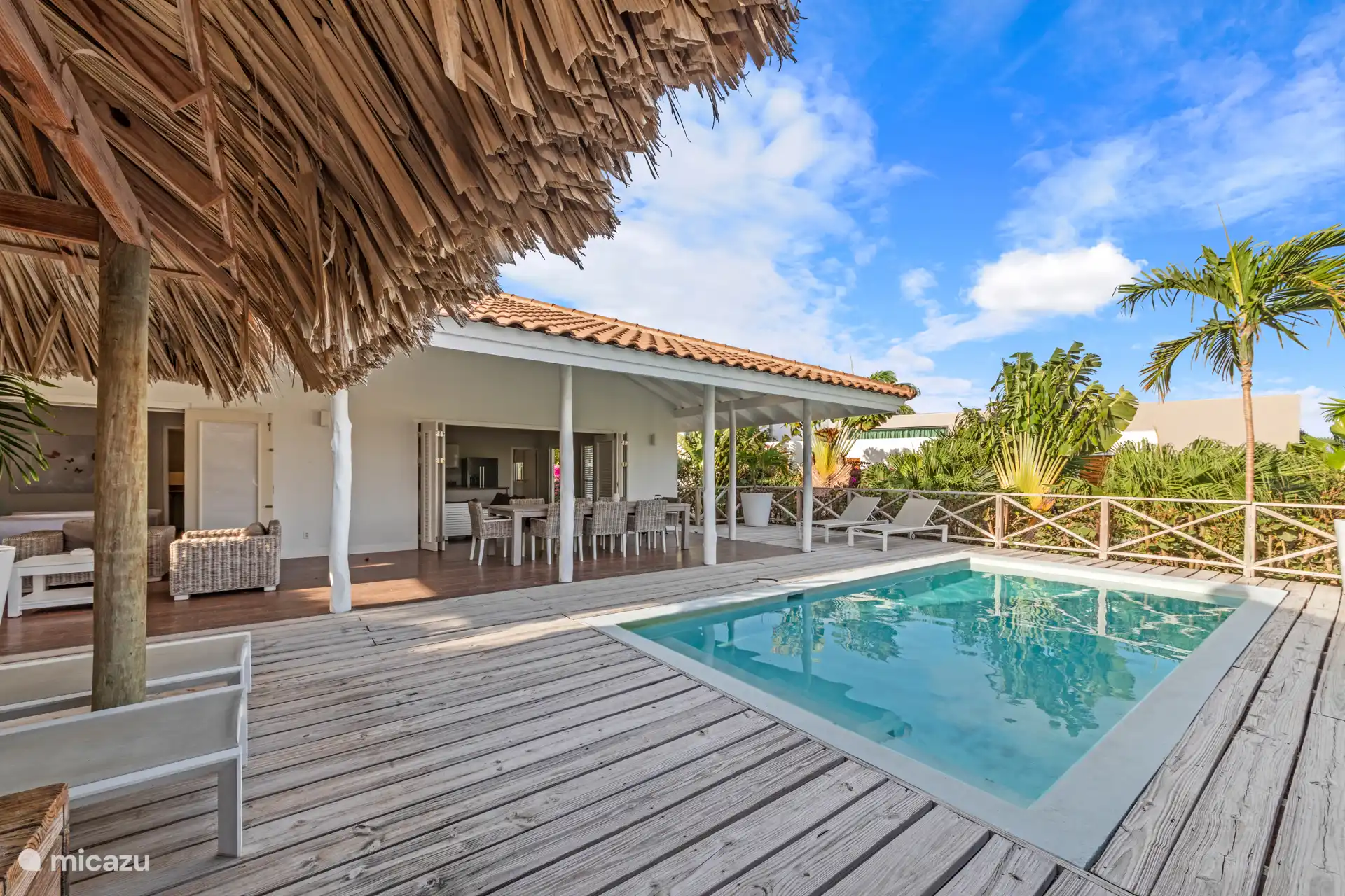 Wenn Sie in den Garten fahren, treten Sie ins Paradies ein. Bunte Blumen, sich wiegende Palmen, ein Swimmingpool mit Sonnenliegen, eine Palapa, ein schönes Lounge-Set und ein großer Esstisch draußen unter dem Rand