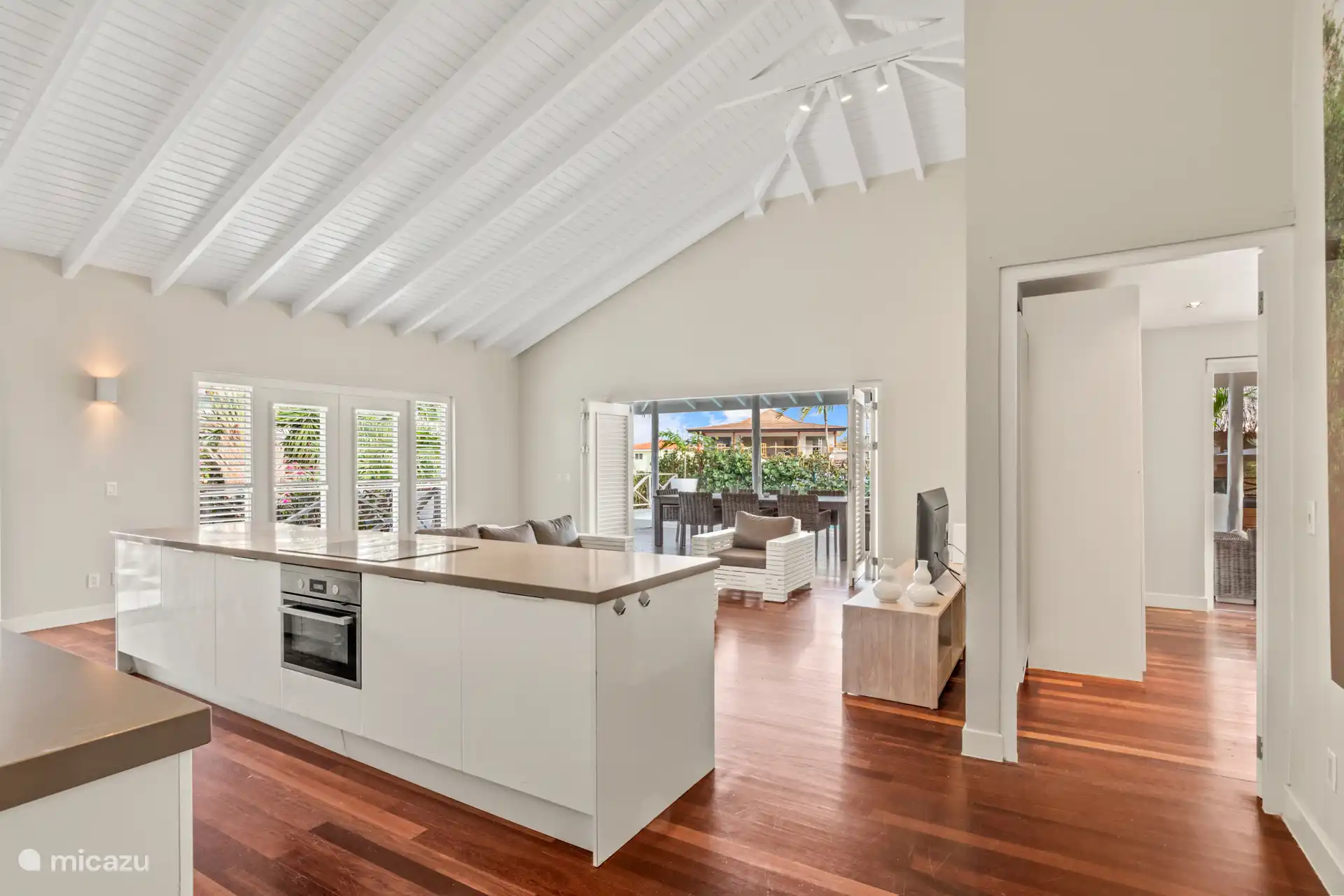 Geräumiges Wohnzimmer mit hohen Decken, gemütlicher Sitzecke und offener Küche