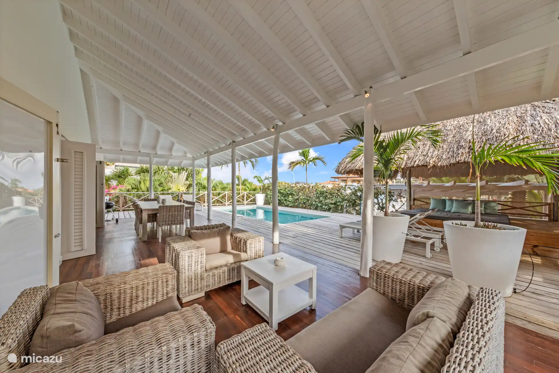 Große überdachte Terrasse mit Lounge-Set und Esstisch.