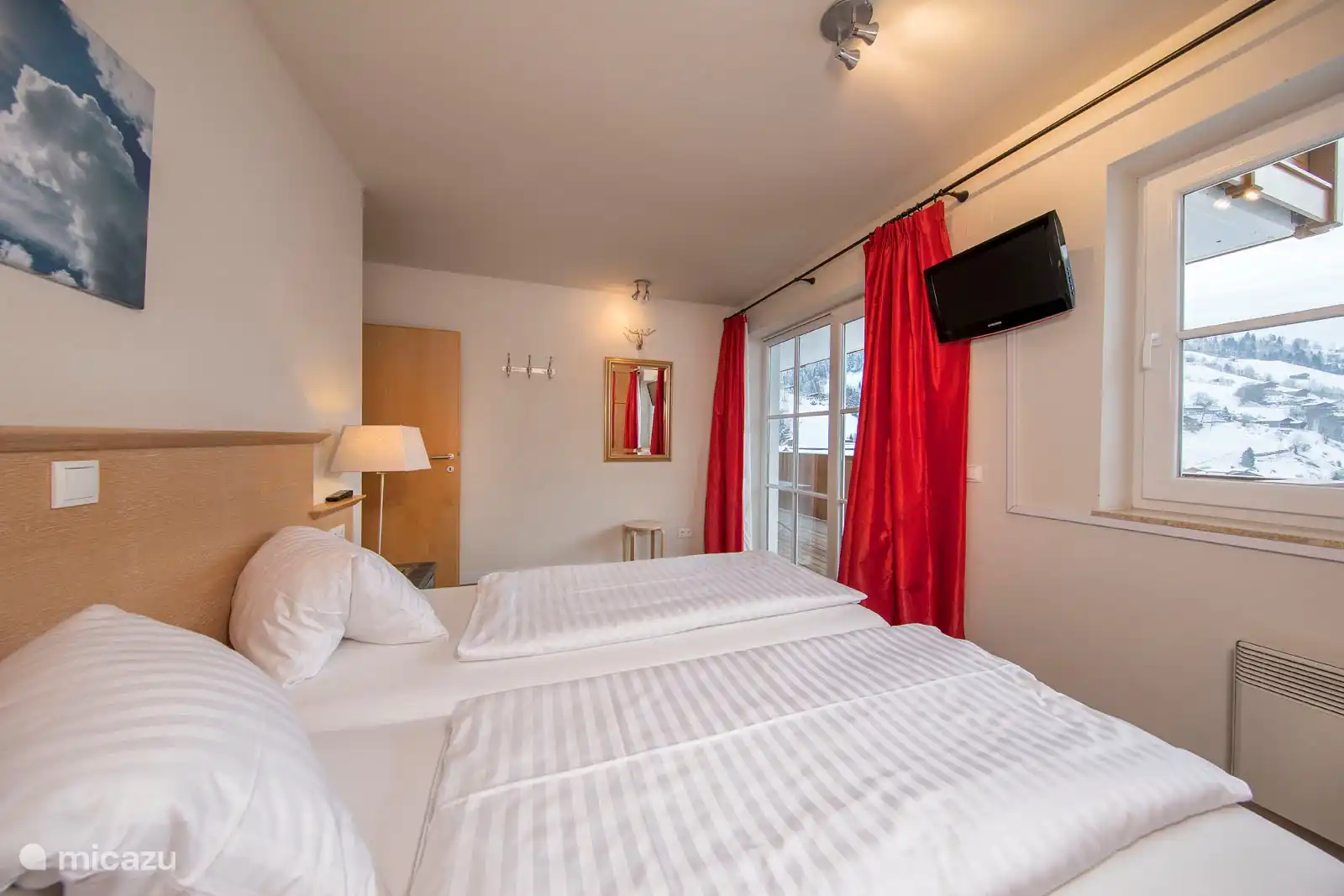 Slaapkamer 1 met een tweepersoonsbed en toegang tot het balkon.