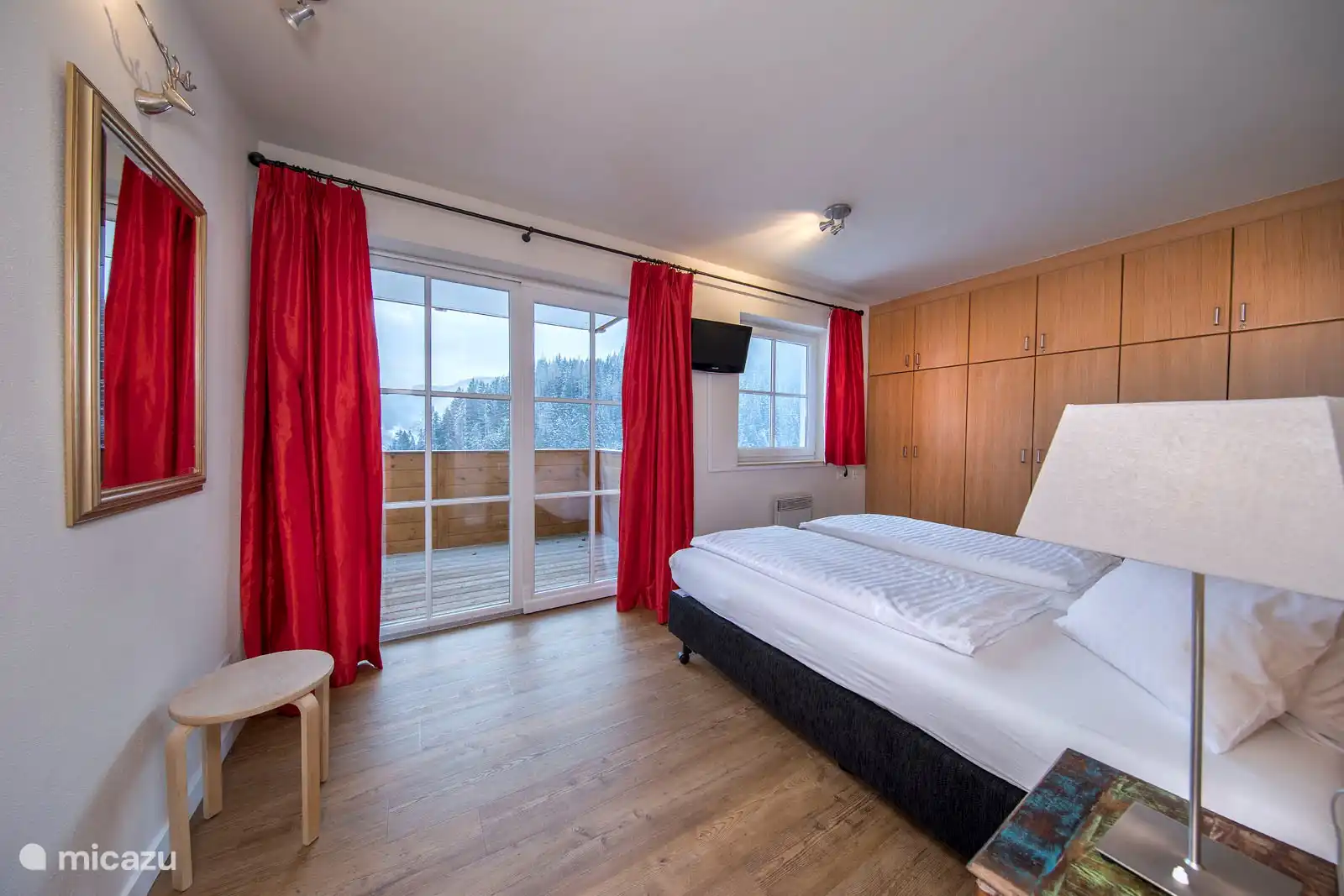 Slaapkamer 1 met een tweepersoonsbed en toegang tot het balkon.