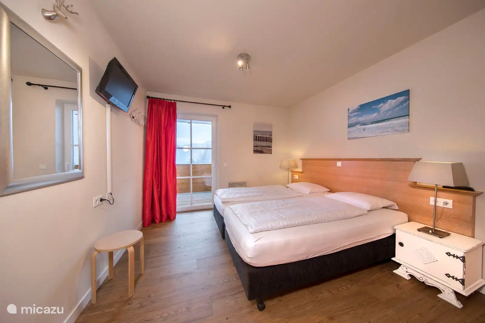 Slaapkamer 2 met een tweepersoonsbed en toegang tot het balkon.