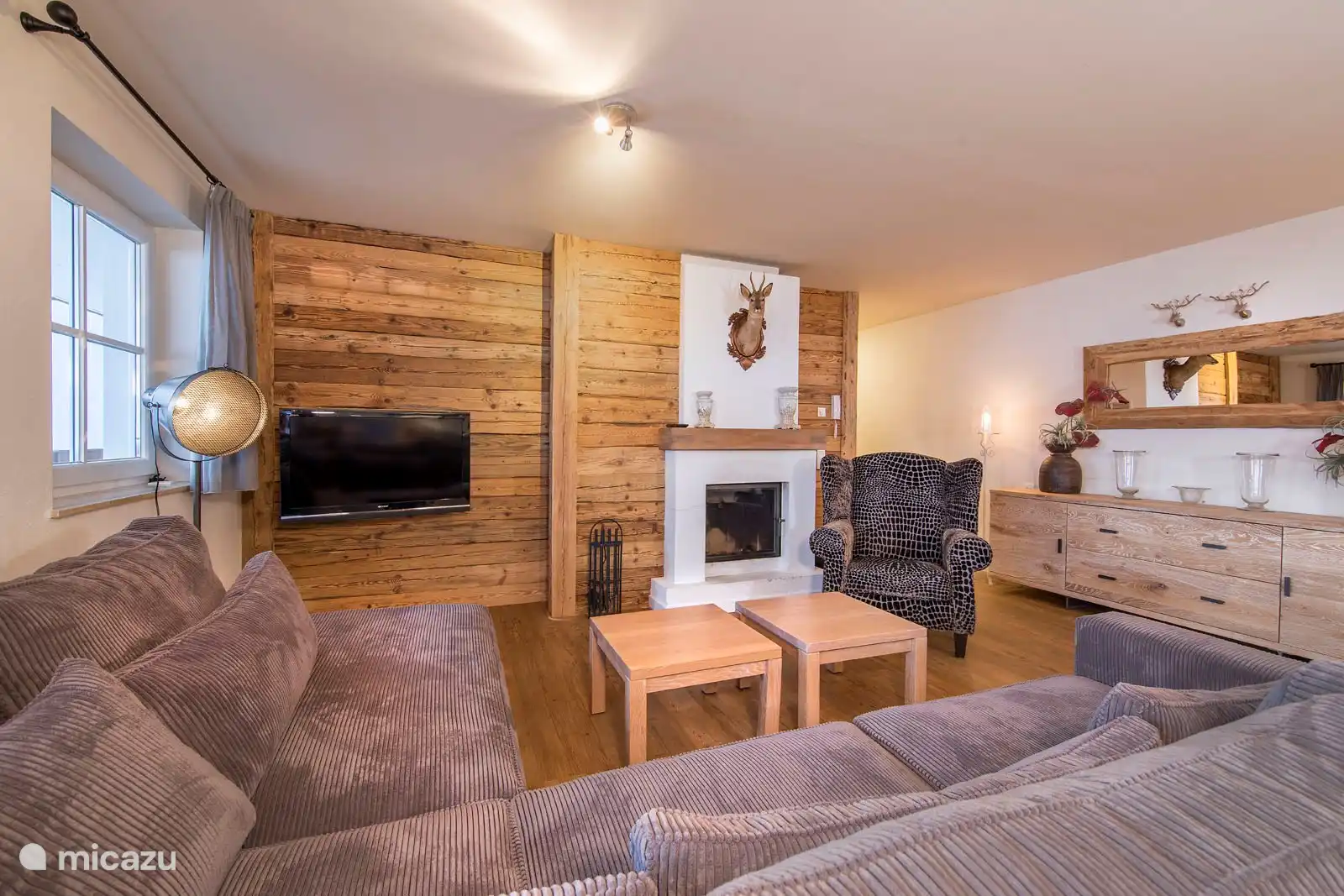 Woonkamer met open haard en heerlijke bank.