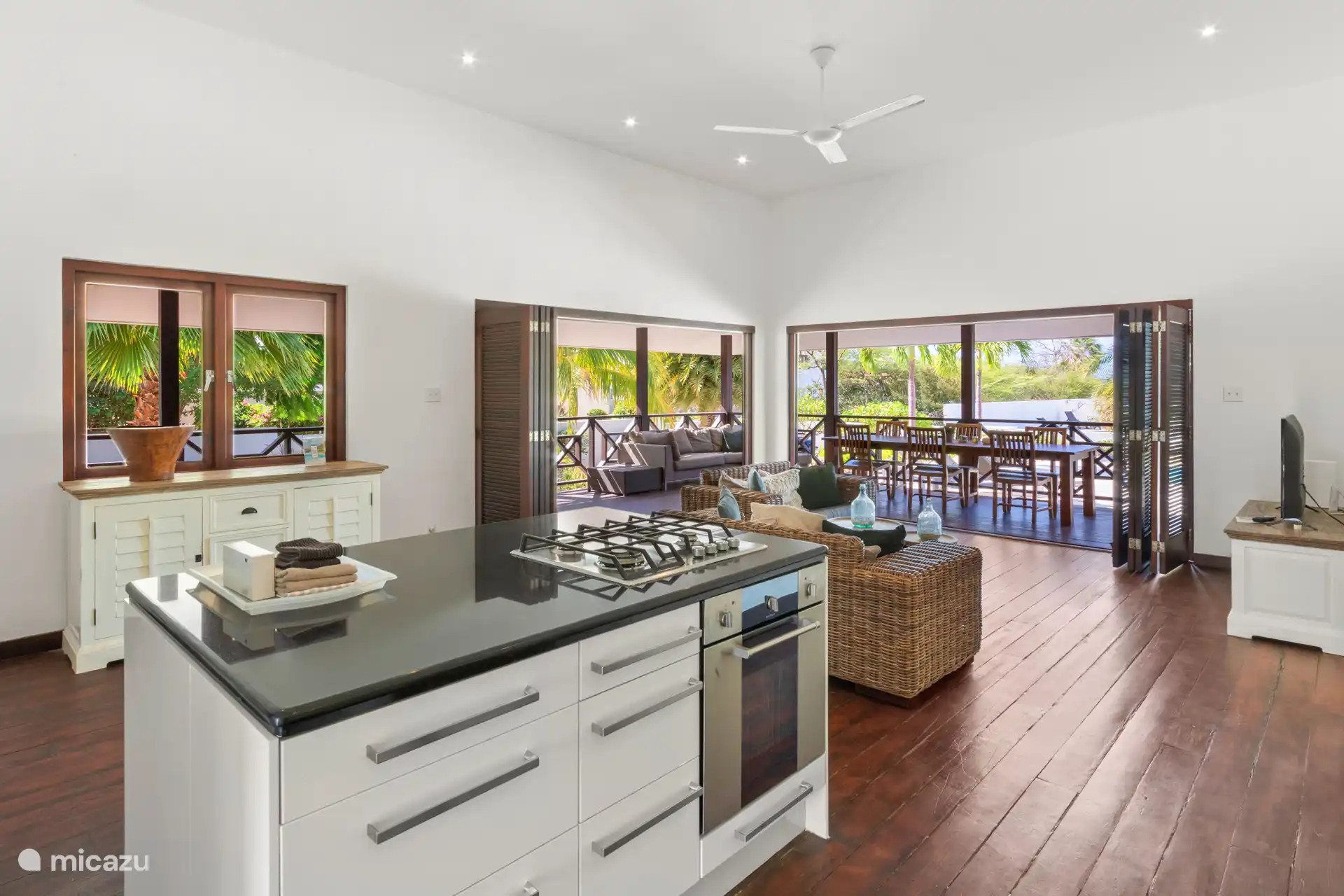 Großes Wohnzimmer mit hohen Decken und luxuriöser offener Küche.