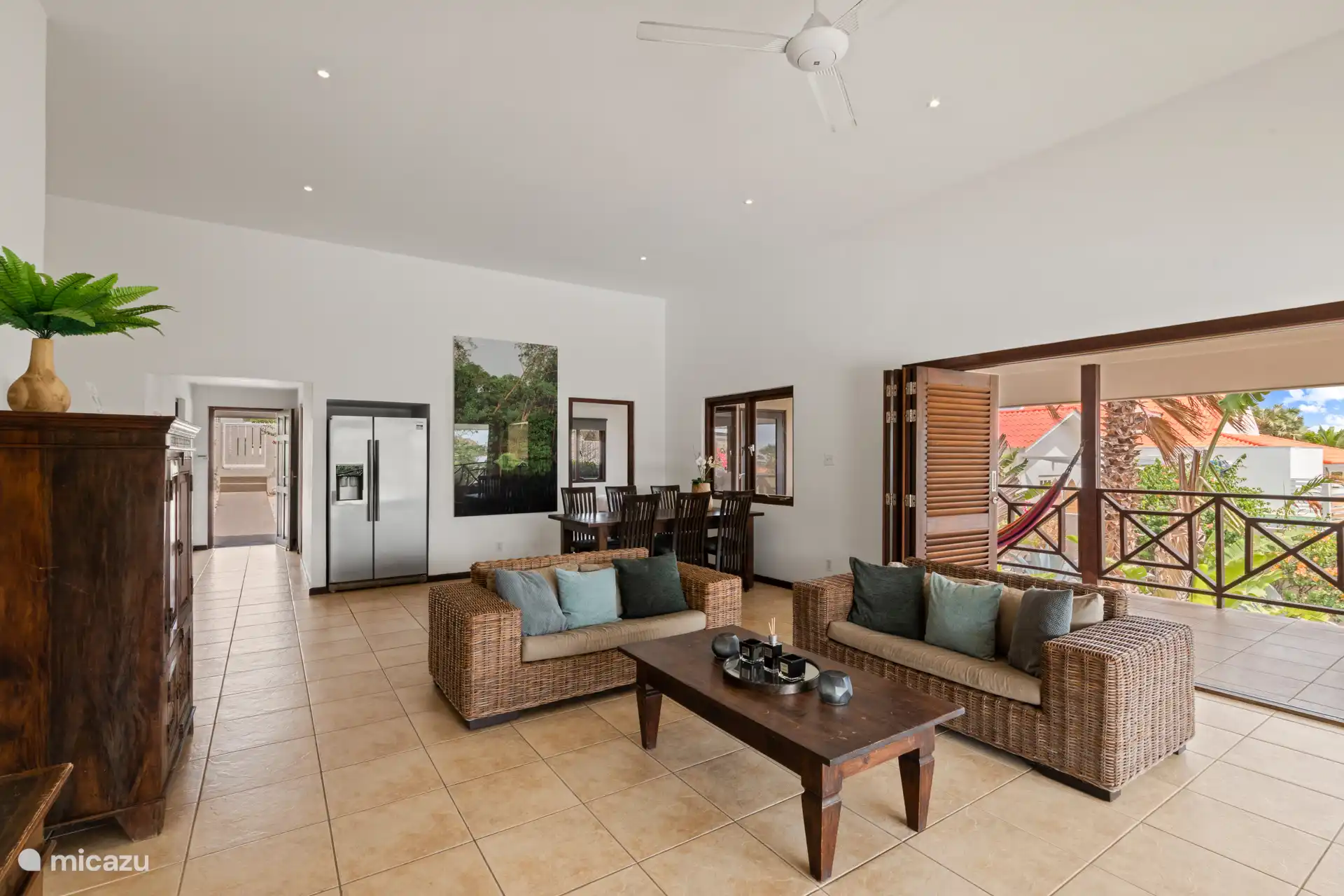 Living room with fan, sitting area, dining area and open kitchen