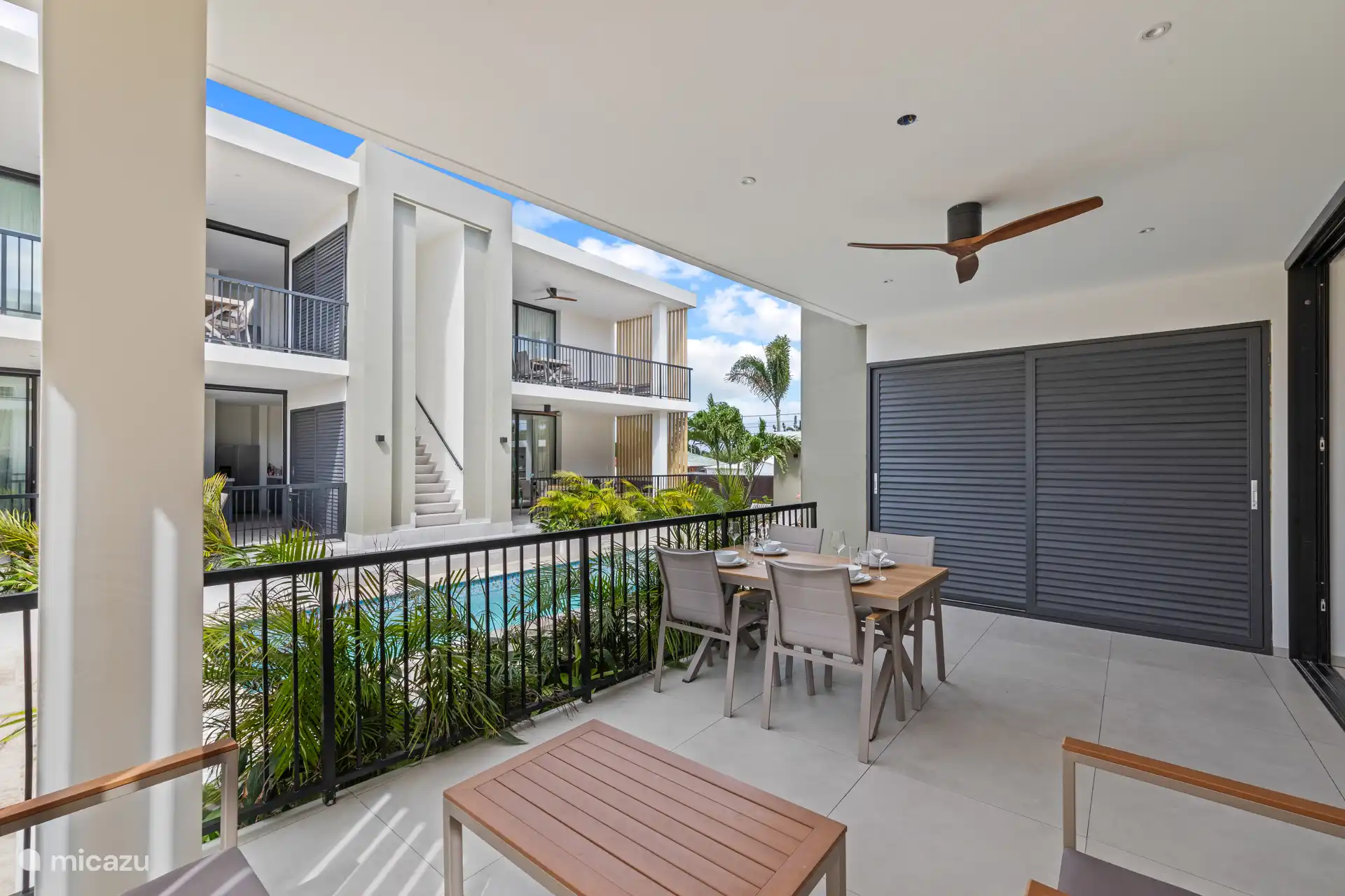 Large private terrace with lounge set, dining table and ceiling fan