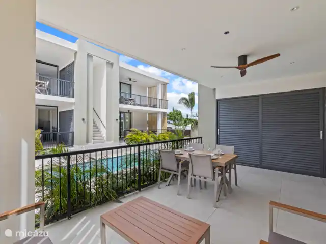 Location de Vacances Curaçao, Banda Ariba (est), Mambo Beach, appartement - Crystal Sands Resort Curaçao Grande terrasse privée avec salon de salon, table à manger et ventilateur de plafond