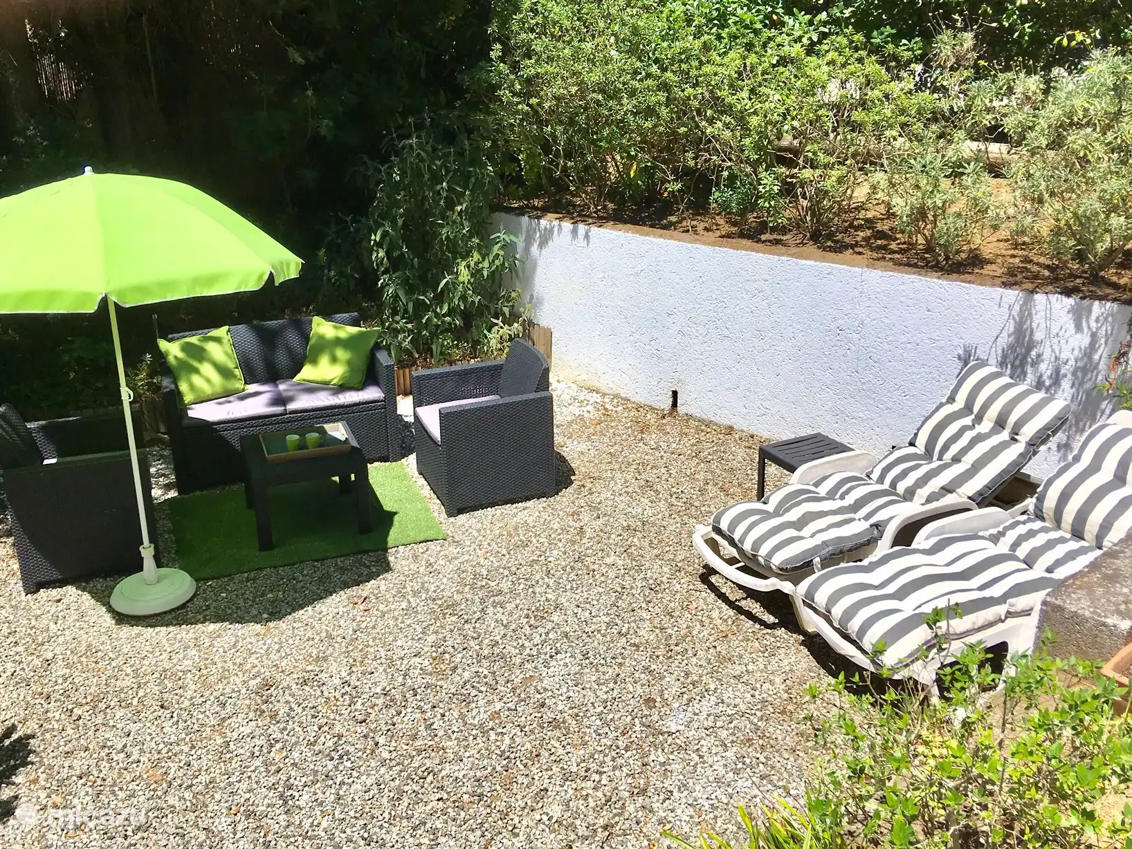 Garten mit Lounge-Set, Liegestühlen und einer Hängematte