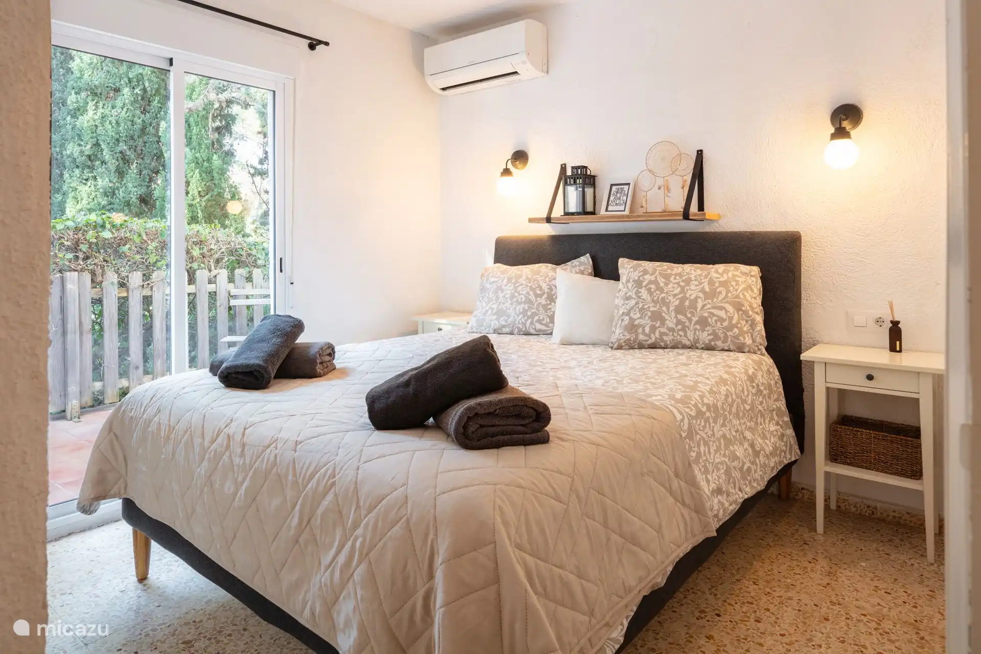Bedroom 1, with sliding doors to the terrace and a large wardrobe and TV.