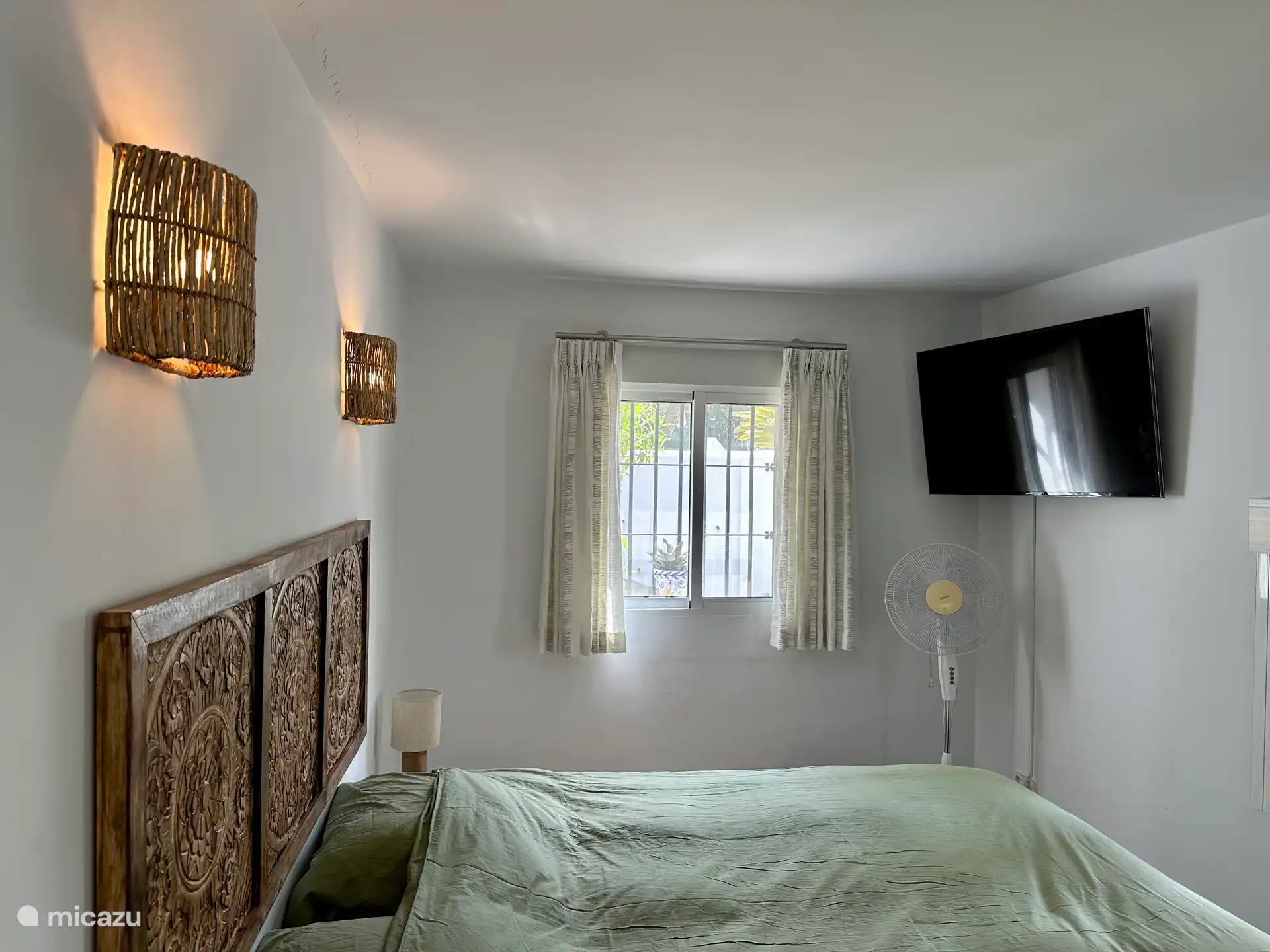 Schlafzimmer 2, Doppelbett mit jeweils eigenem Nachttisch, Garderobenständer, Wäschekorb, Smart-TV, Chromecast, Ventilator, Fenster.