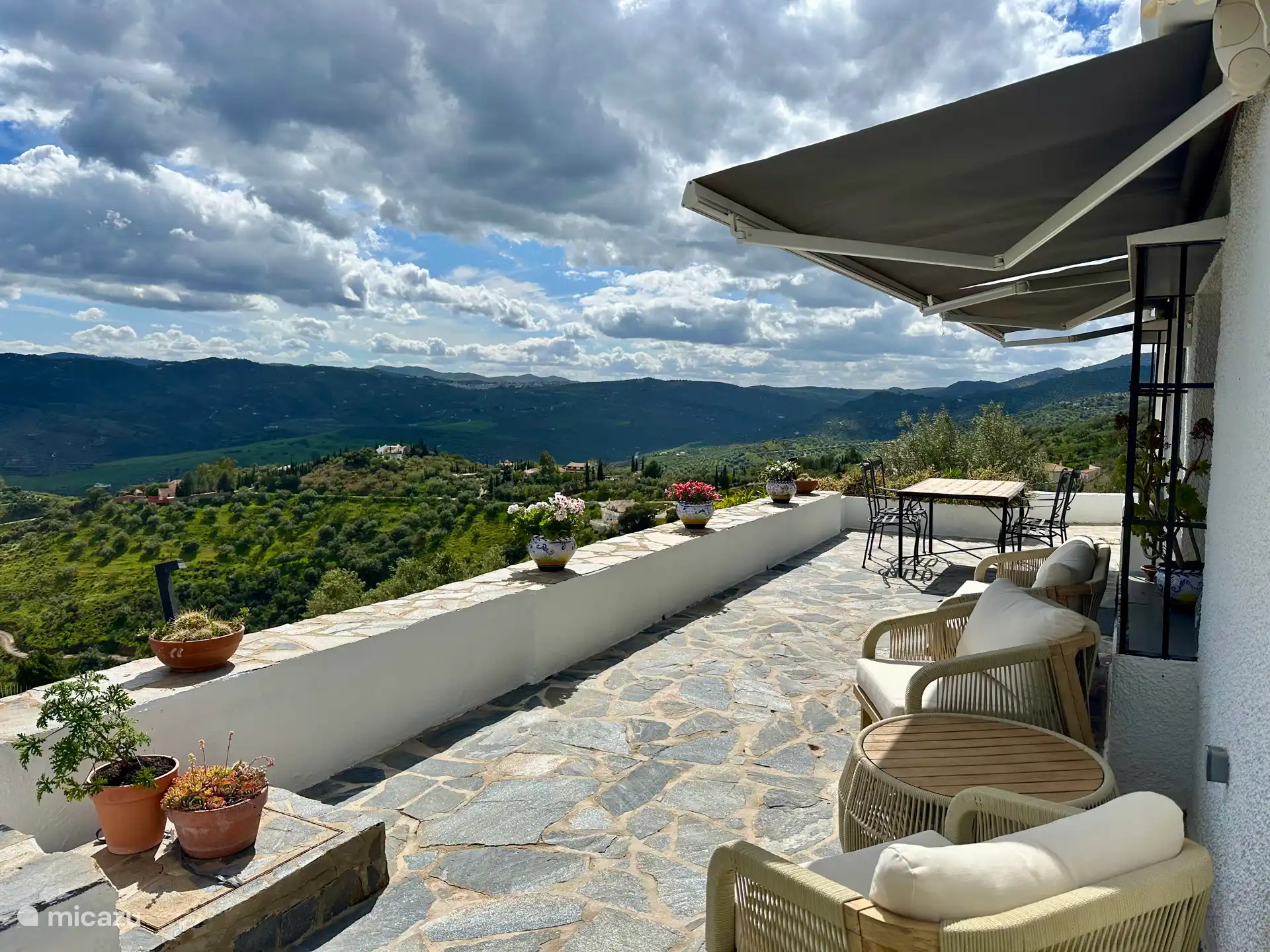 Panoramaterrasse an der Seite der Küche und Esstisch mit luxuriösen Liegestühlen und herrlicher Aussicht. Im Sommer weht oft eine leichte Brise.