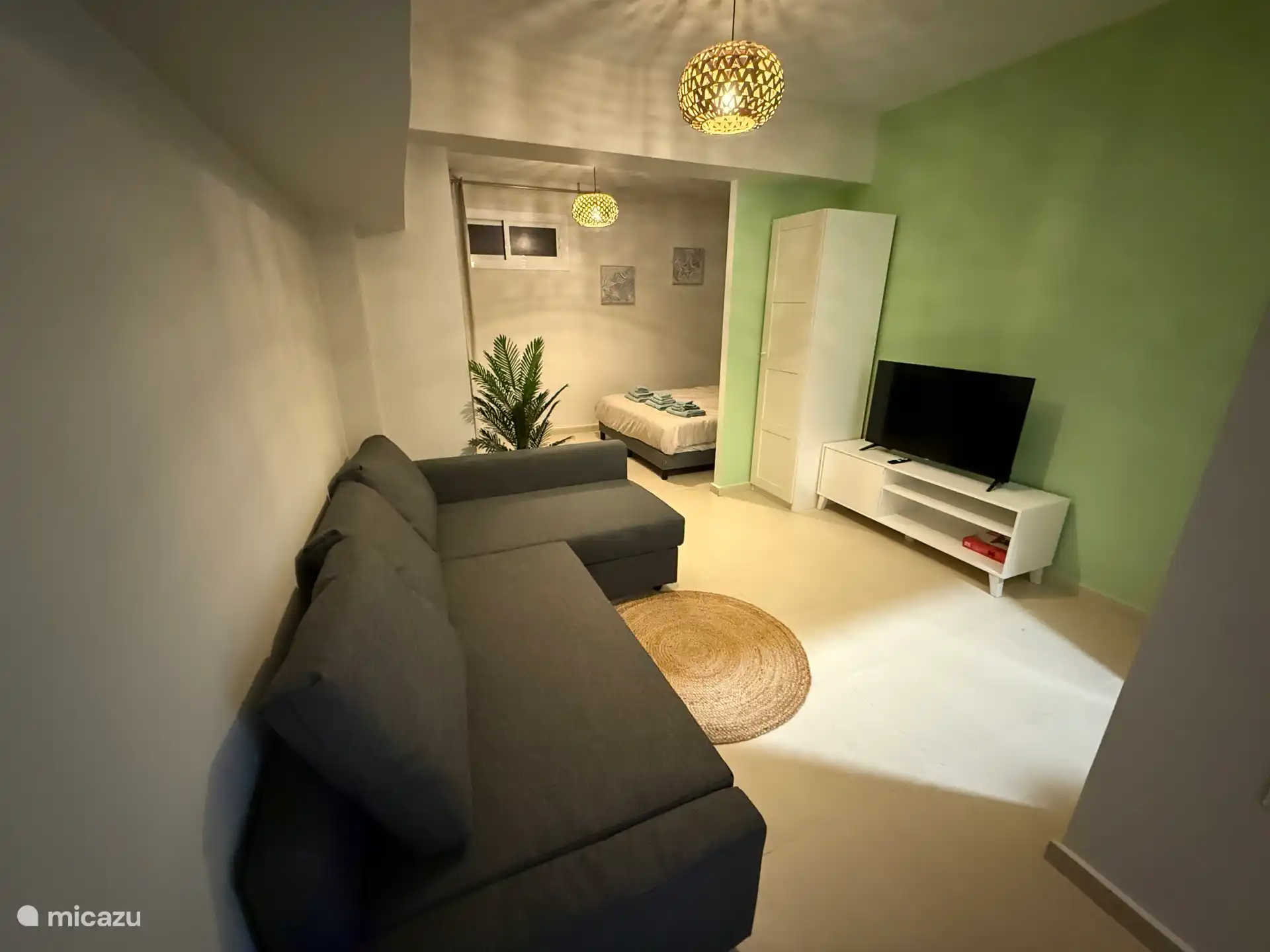 Basement with double bed (200x200), sitting area/sofa bed (140x200), TV and home office.