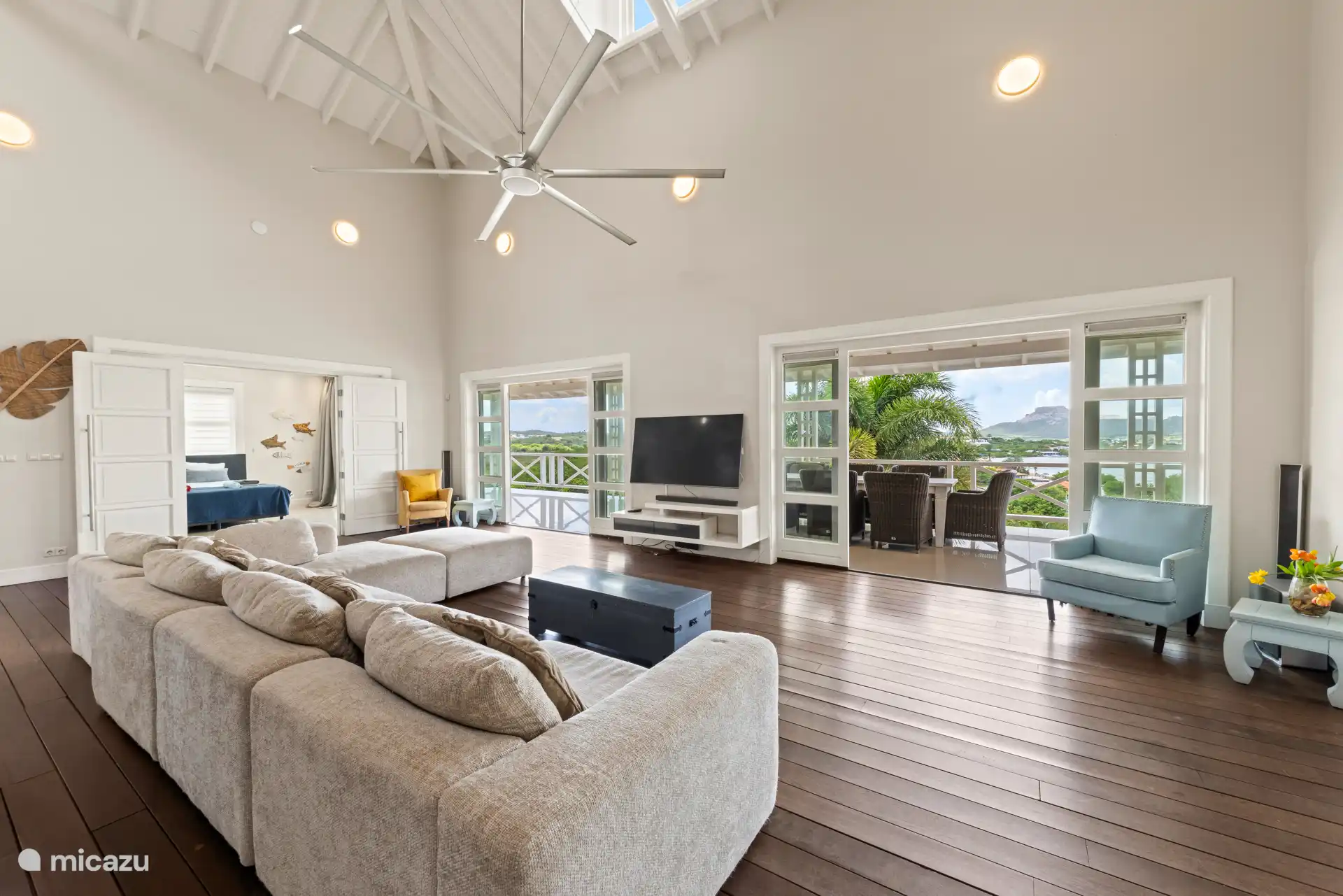 Geräumiger und heller Wohnraum, der nahtlos in einen großen, überdachten Balkon übergeht.