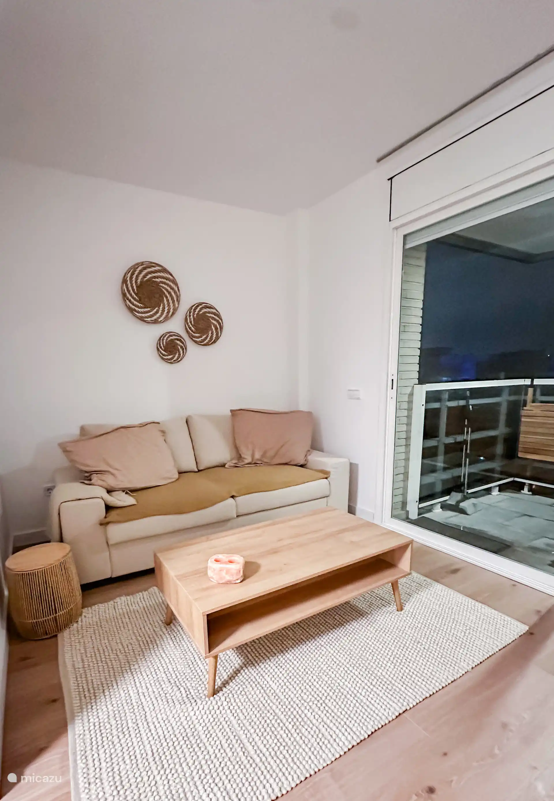 Woonkamer met (slaap)bank en toegang tot het balkon