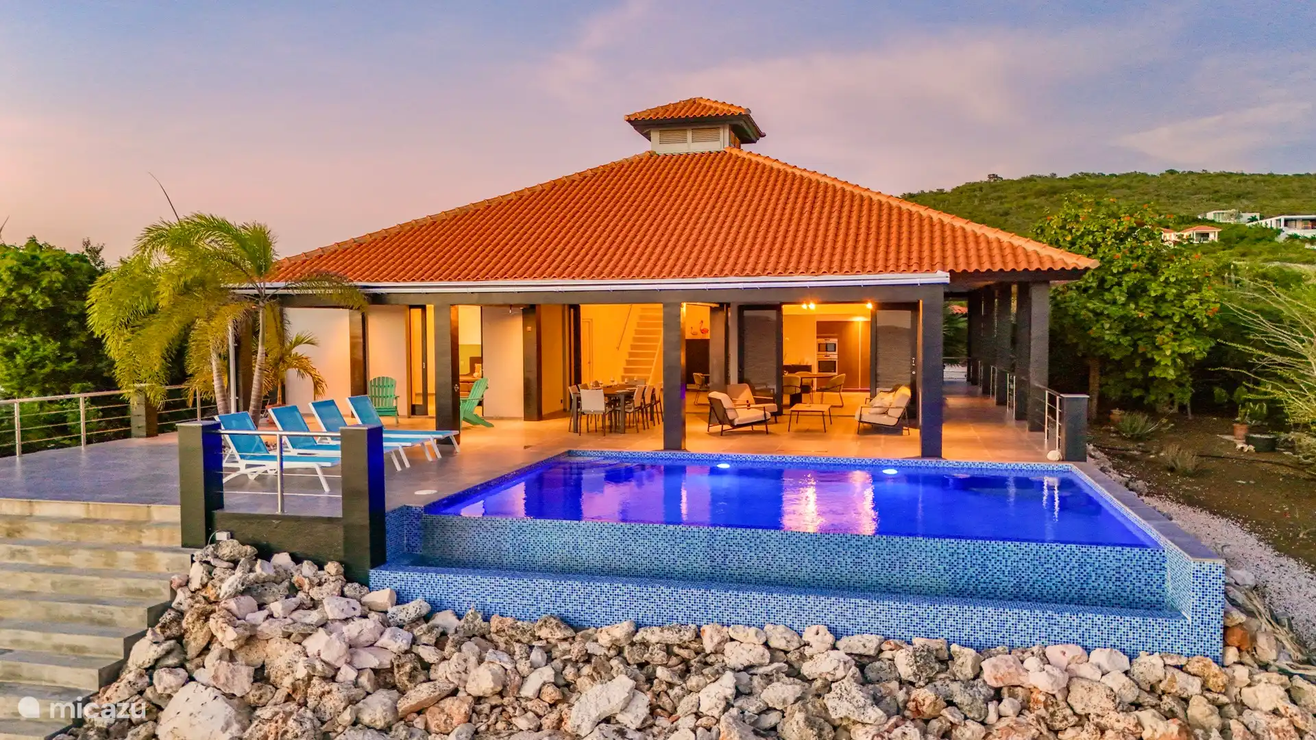 Hier sehen Sie einen vollständigen Überblick über die Terrasse, mit einem Teil des Hauptschlafzimmers hinten links und der Küche sowie der Treppe zum offenen Loft hinten rechts