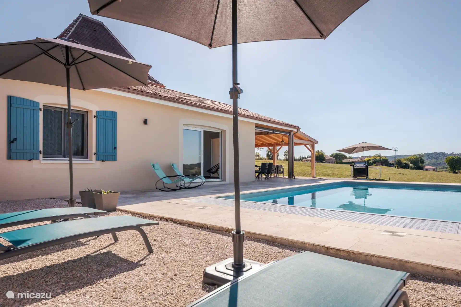 Piscine avec terrasses, lits et chaises