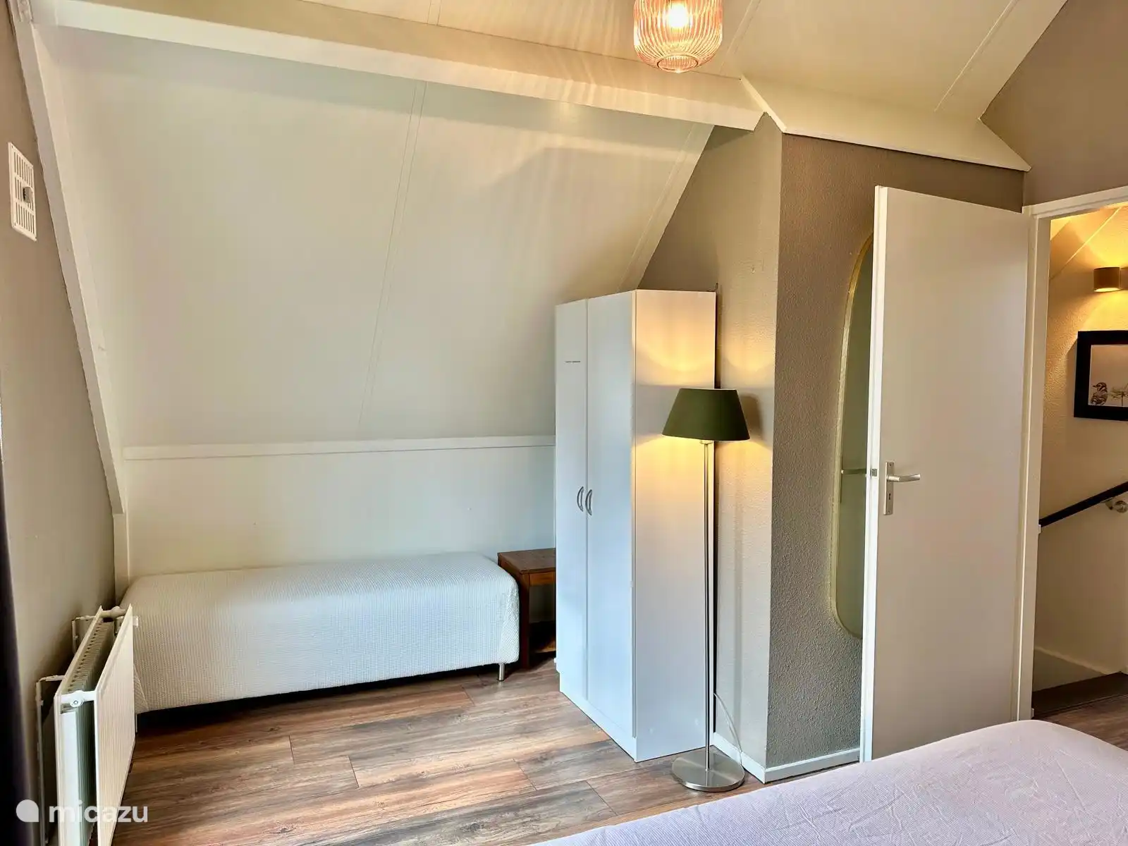 Upstairs bedroom with double bed. There is a bench to sit on and a closet with extra duvets