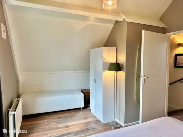 6p. Boshuis *Jacuzzi*De Groene Specht | Pays-Bas, Gueldre, Ewijk - maison de vacances Chambre à l’étage avec lit double. Il y a un banc pour s’asseoir et un placard avec des couettes supplémentaires