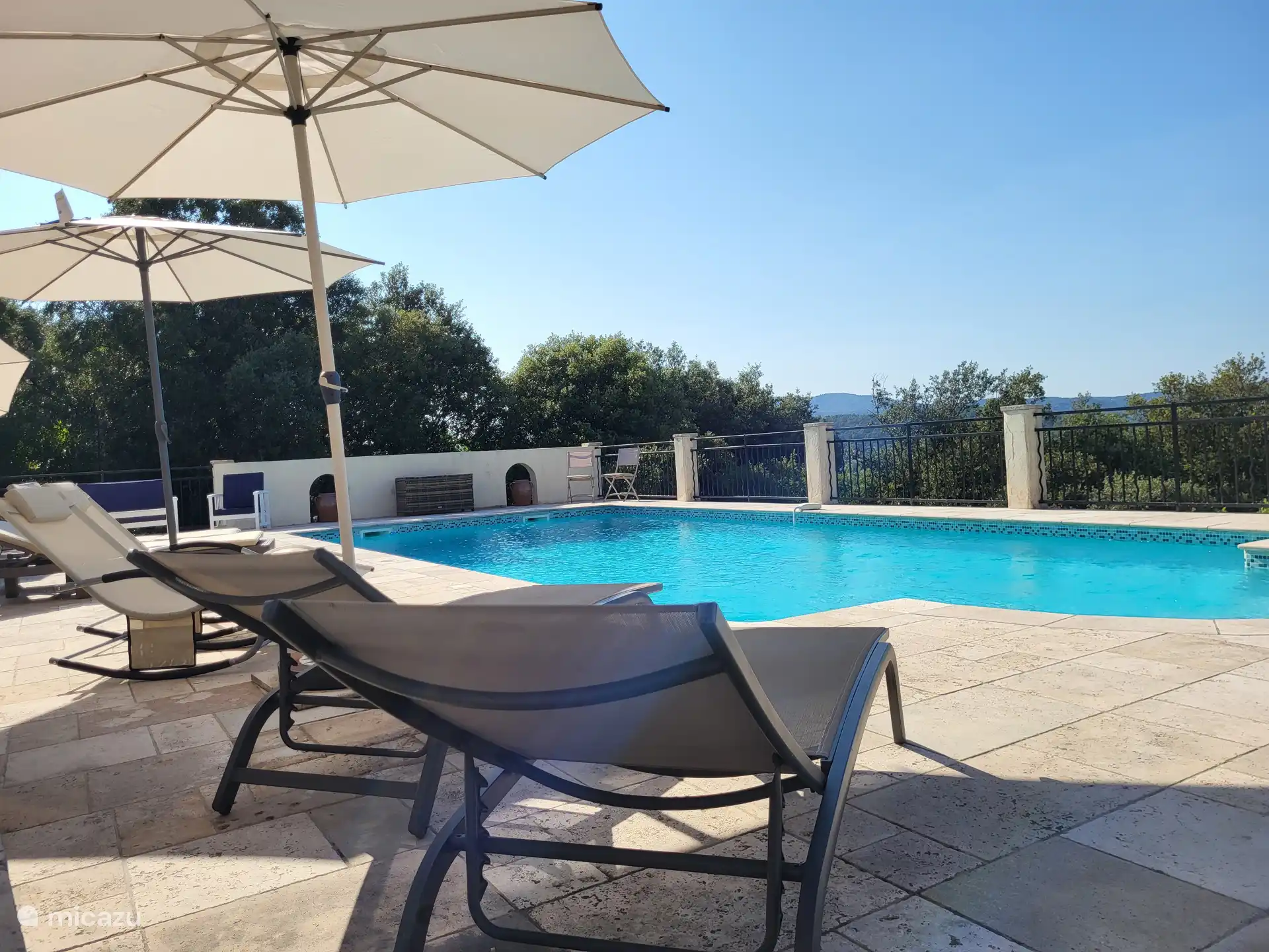 sunbeds with umbrellas by the pool