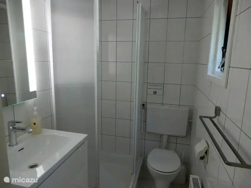 Angenehmes Badezimmer mit guter Beleuchtung und genügend Stauraum für Ihre Sachen.