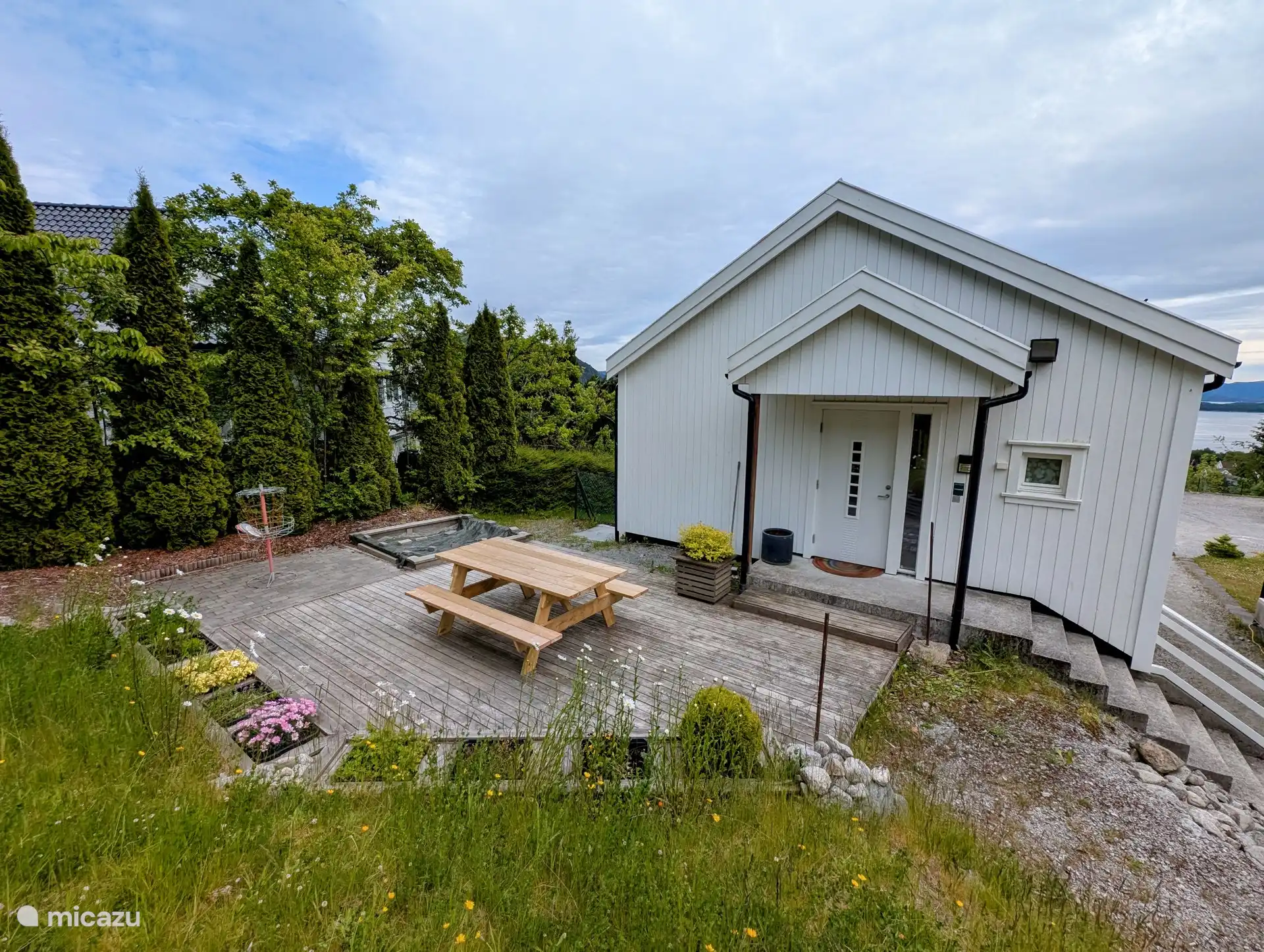 Cour arrière avec coin salon et barbecue.