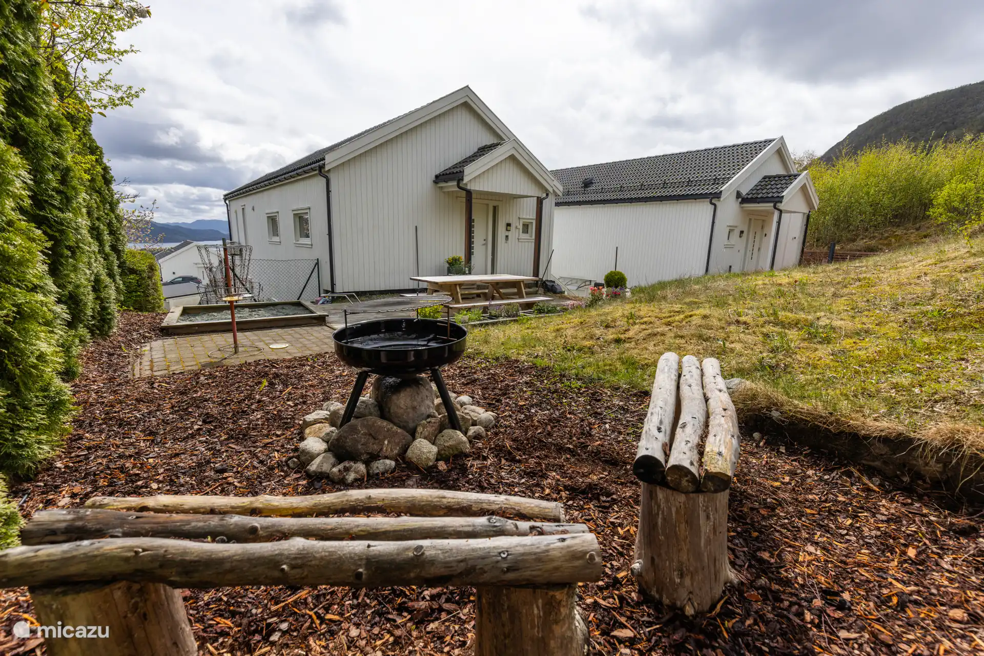 Le jardin privé derrière l’appartement comprend une terrasse avec un coin salon, un barbecue, un bac à sable et un panier à frisbee. 