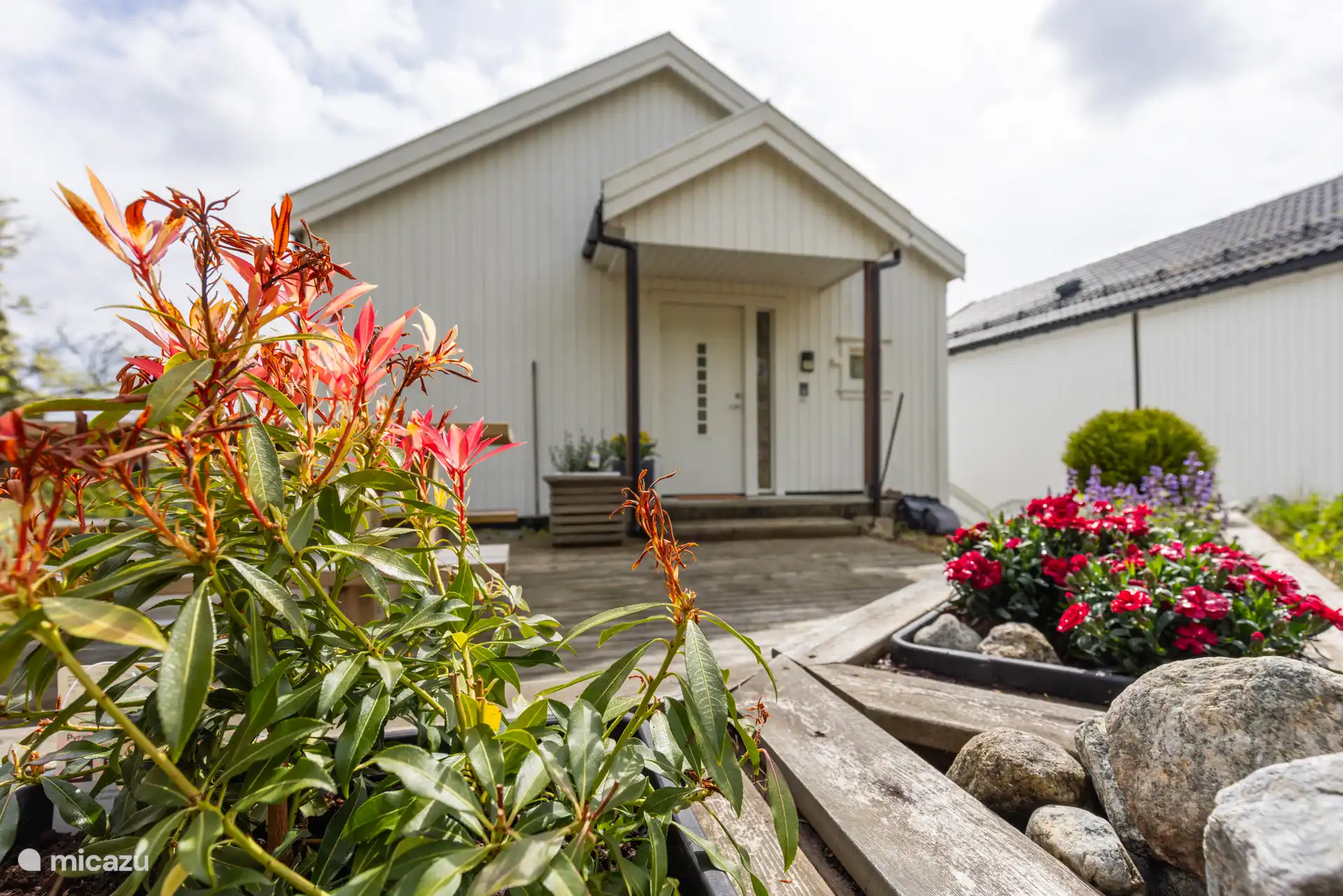 Le jardin privé derrière l’appartement comprend une terrasse avec un coin salon, un barbecue, un bac à sable et un panier à frisbee. 