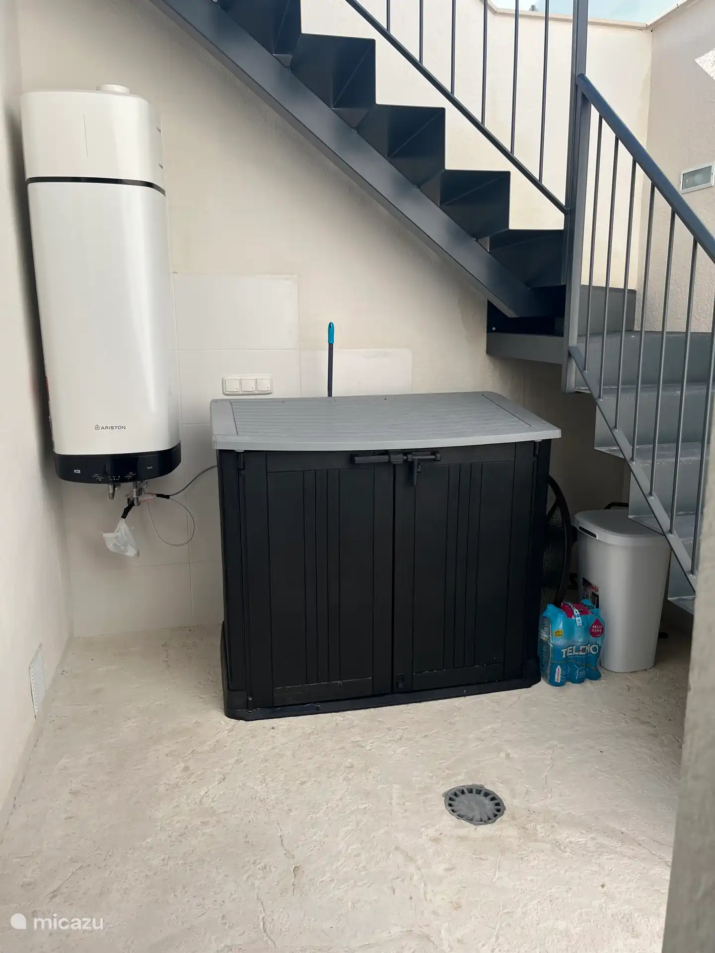 Debajo de las escaleras hay una caja con una lavadora dentro