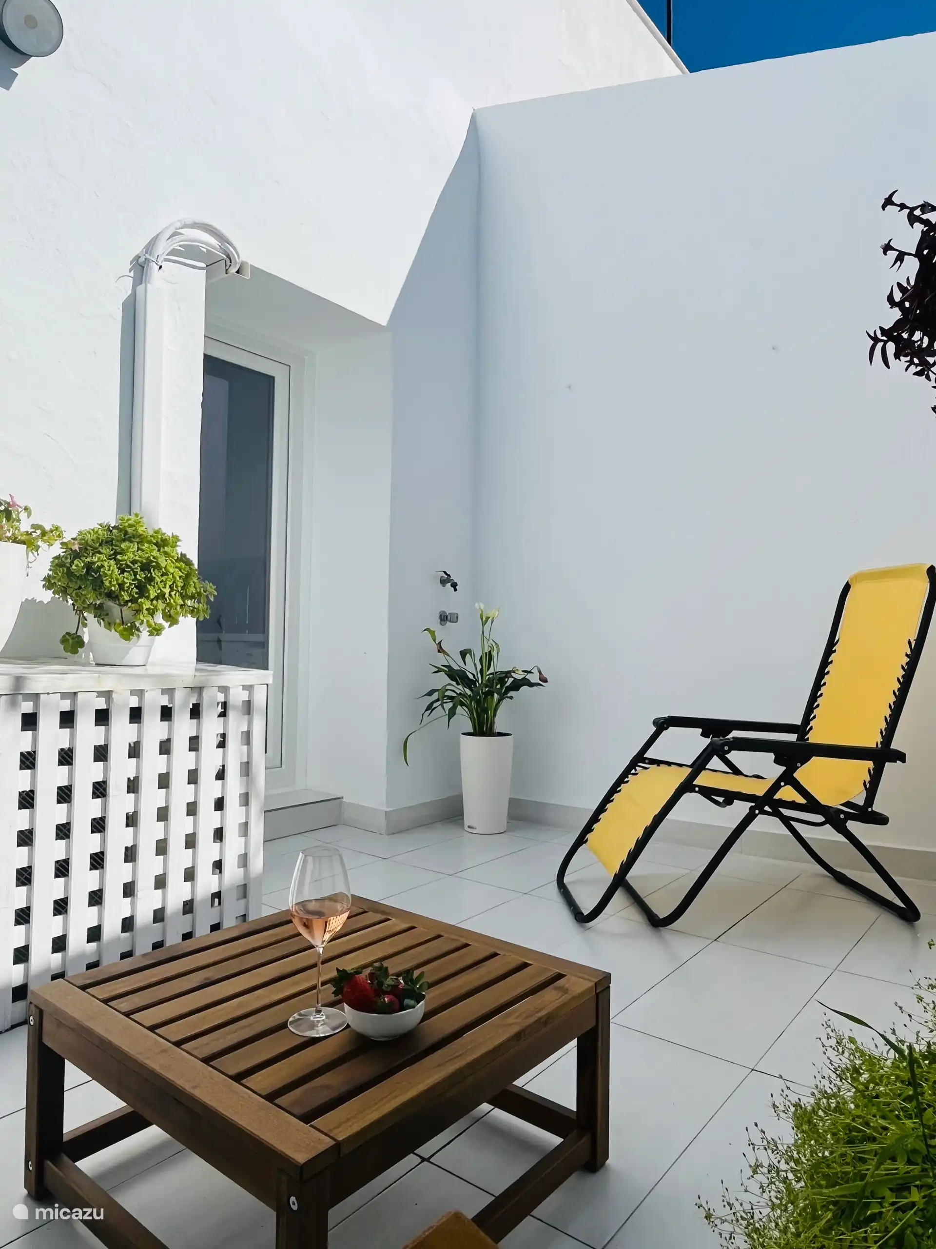 Private Terrasse mit Zweisitzerbank, Tisch und Stuhl. 