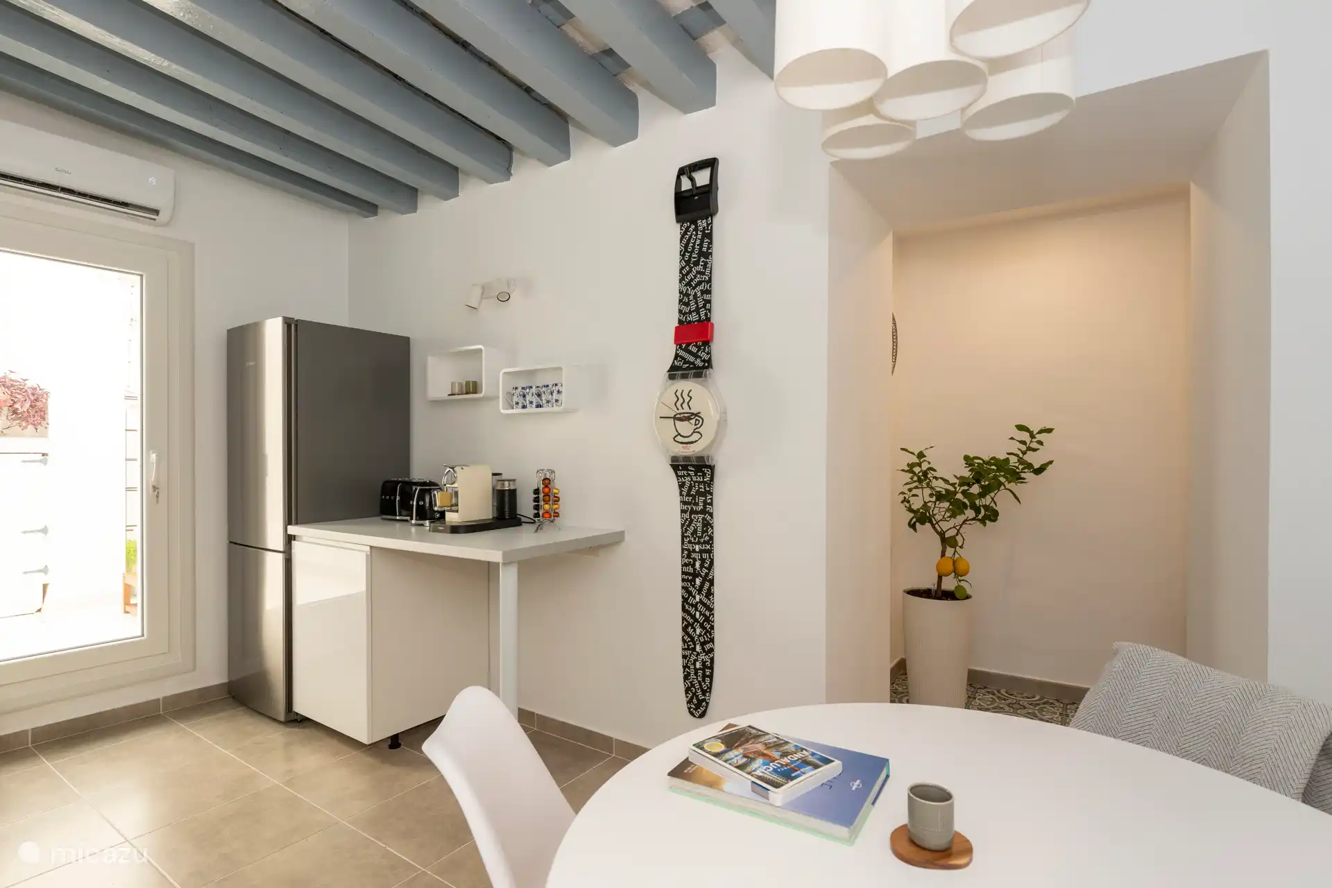 Voll ausgestattete Küche mit Cerankochfeld, Kühlschrank, Waschmaschine, Tisch mit 4 Stühlen, Nespresso-Kaffeemaschine, SMEG-Wasserkocher und Toaster sowie Klimaanlage/Heizung.