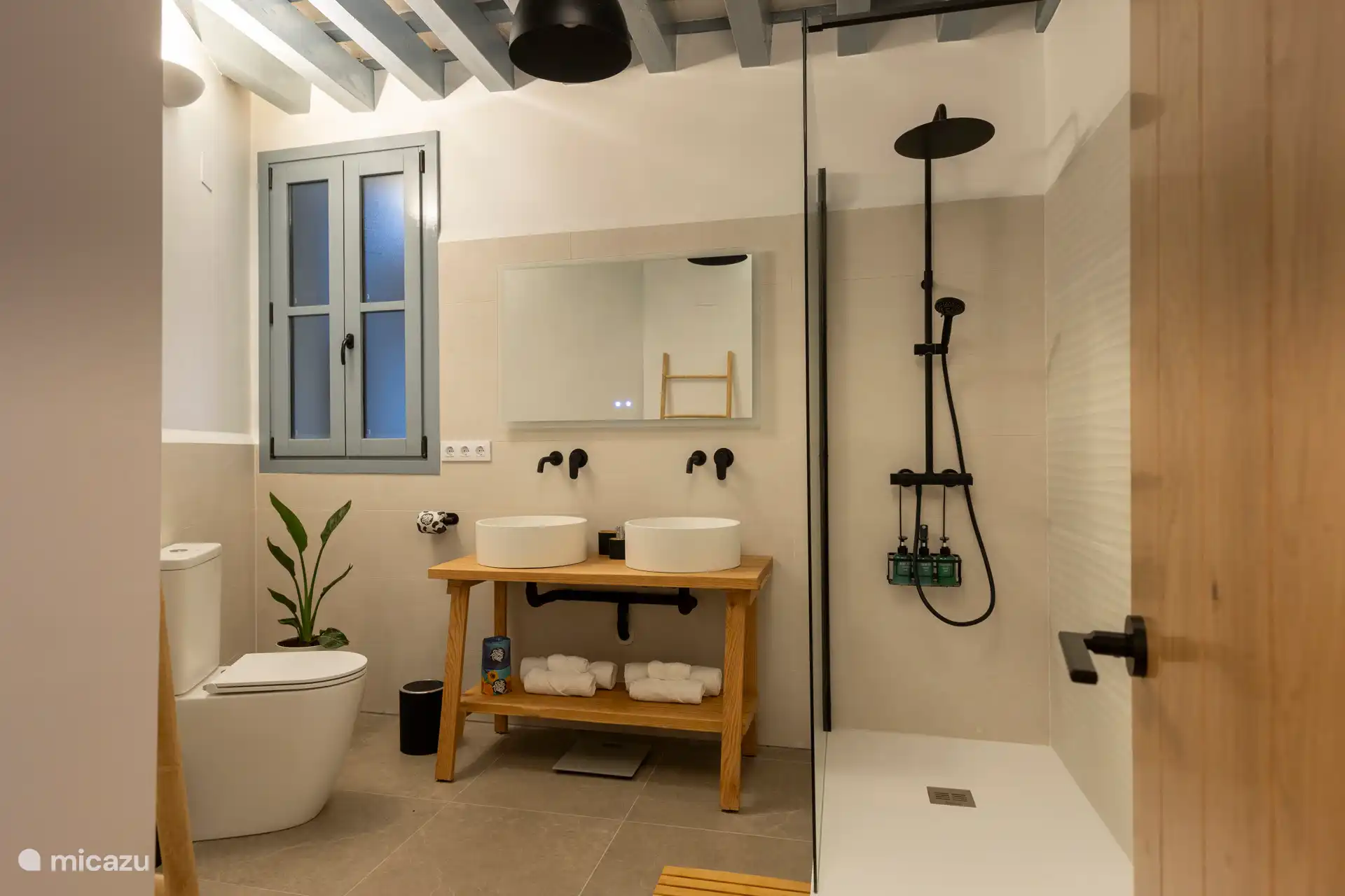 Geräumiges Badezimmer mit begehbarer Dusche, WC, Waschbecken mit 2 Waschbecken, Spiegel mit Licht und Antibeschlagheizung, Pflegeprodukte.