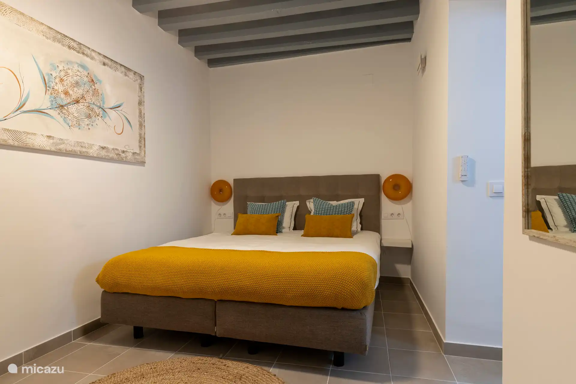 Schlafzimmer mit Kingsize-Bett, Bademänteln, Kommode und Spiegel. Dieses Zimmer verfügt über ein eigenes Bad.