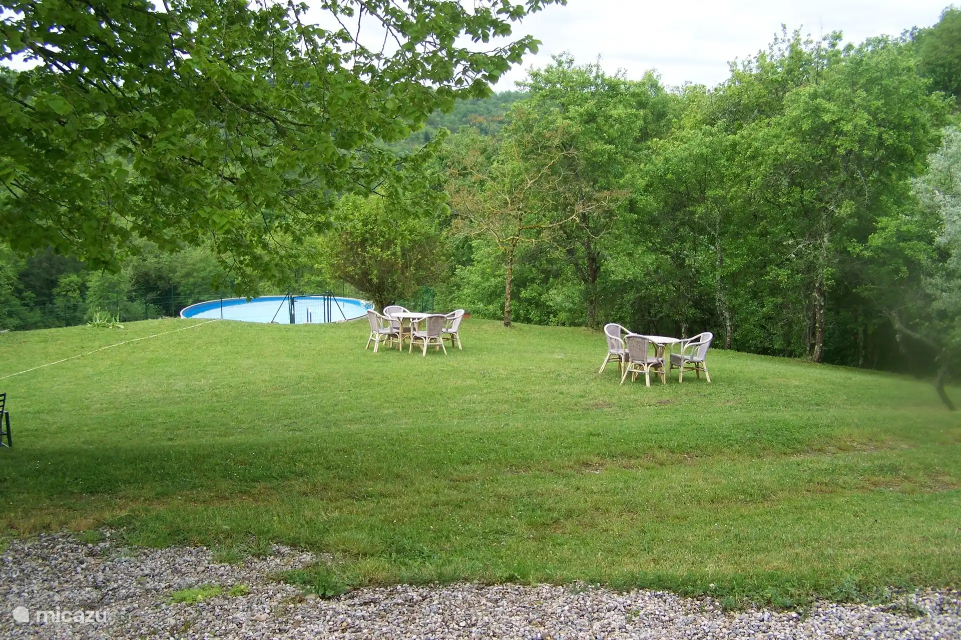 Vista desde la casa sobre el césped para tomar el sol y la piscina