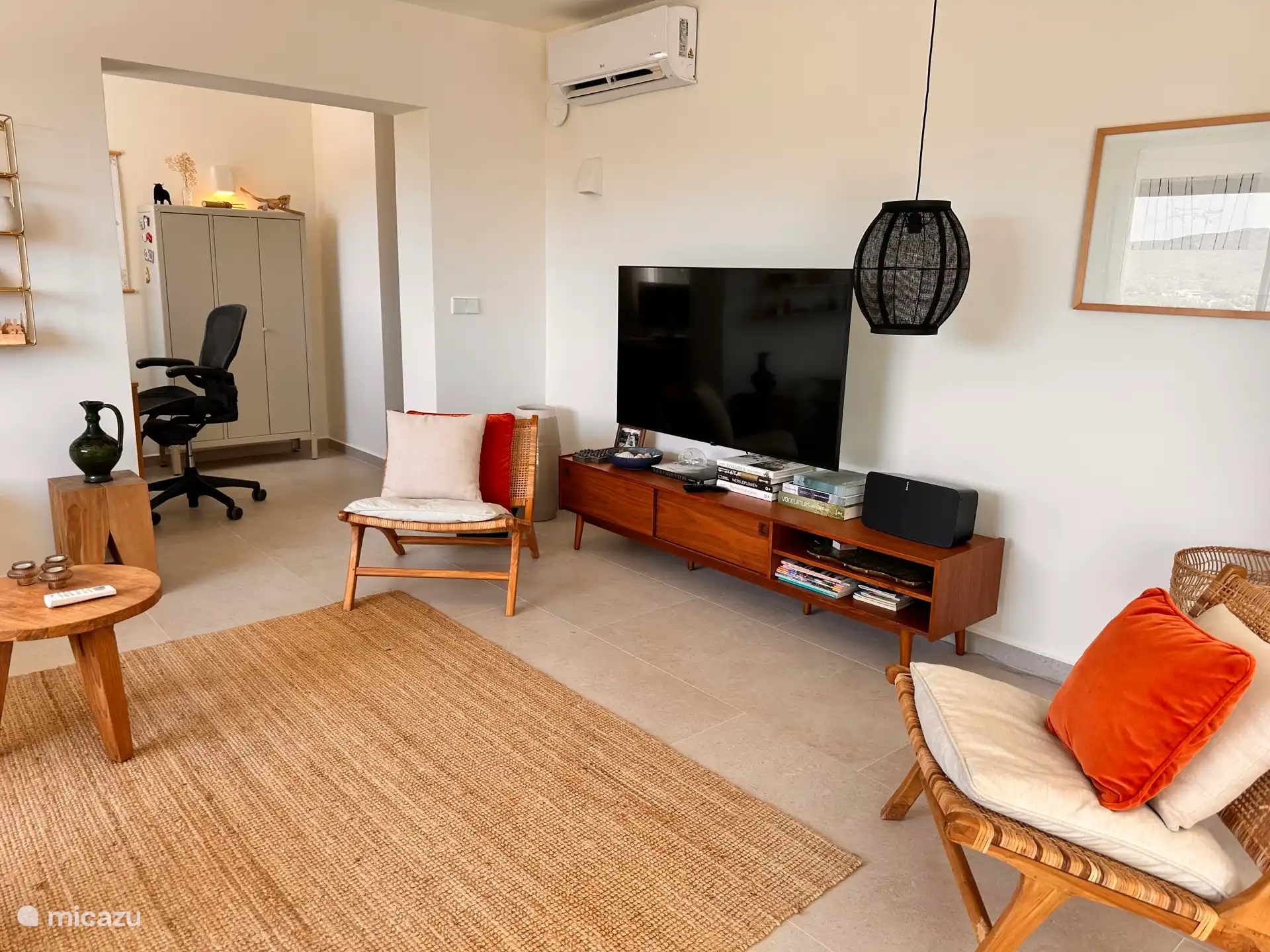 lounge met tv en een apart werkkamer