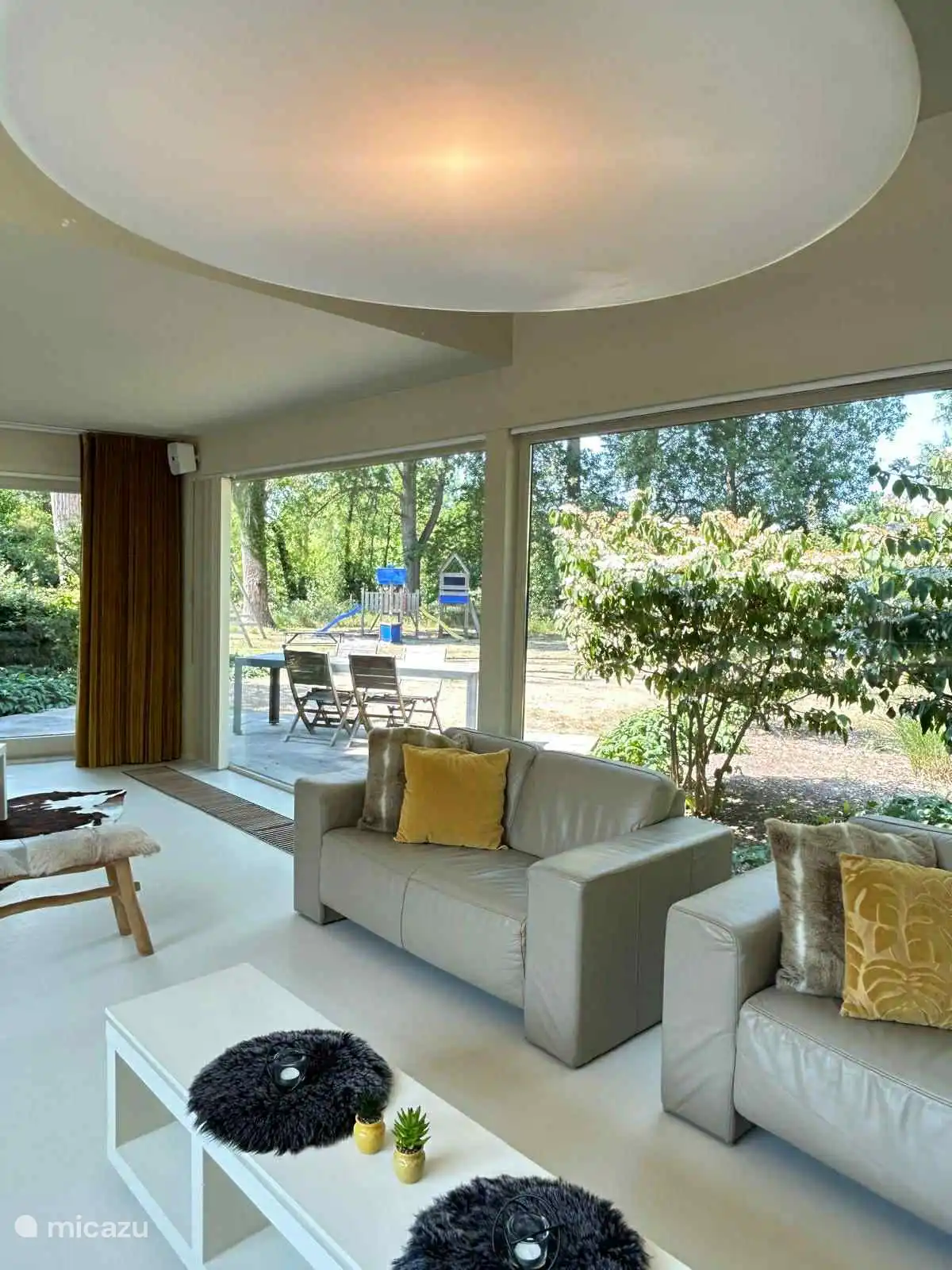 Woonkamer Duinpaviljoen met zicht op speeltuin