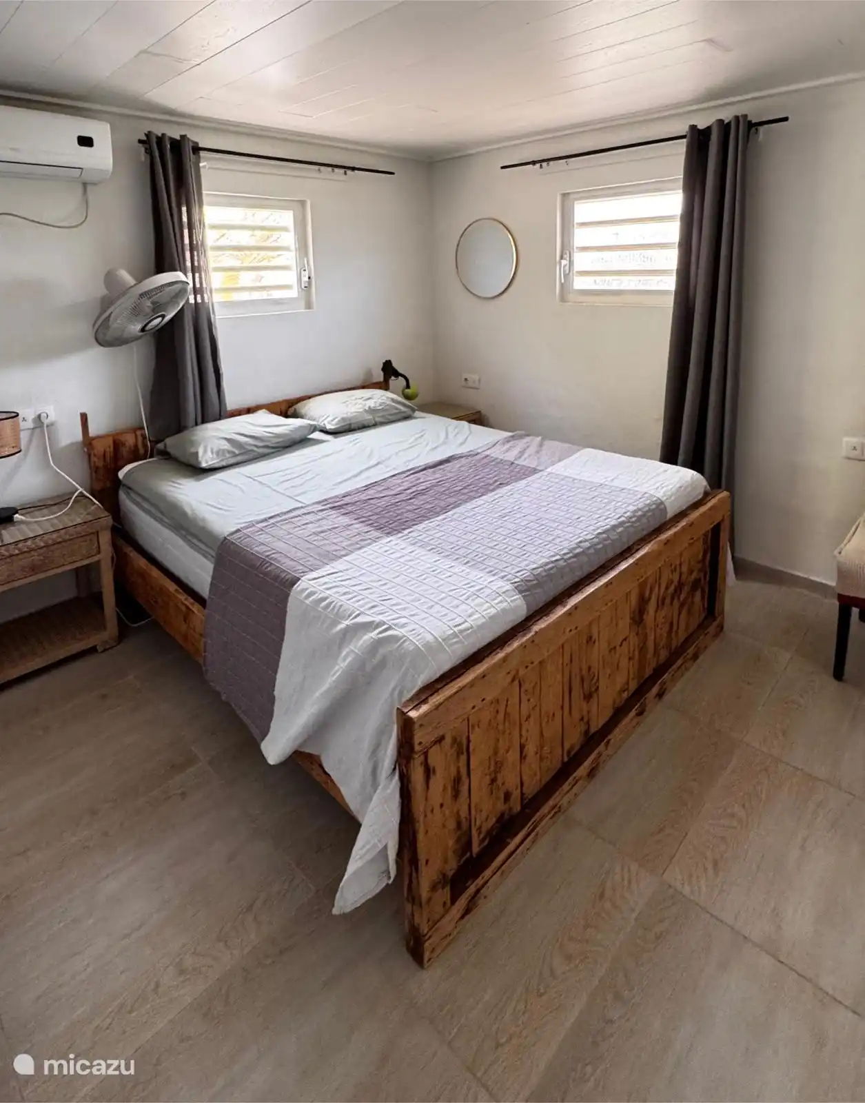 Schlafzimmer mit Klimaanlage, Ventilator und Kleiderschrank.