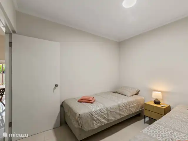 Bunita den Bario Apartments - B | Curaçao, Curaçao-Centre, Willemstad - maison de vacances 2ème chambre avec 2 x lit simple 90x200cm, linge de lit, serviettes, climatisation, étendoir, table de chevet et ventilateur.