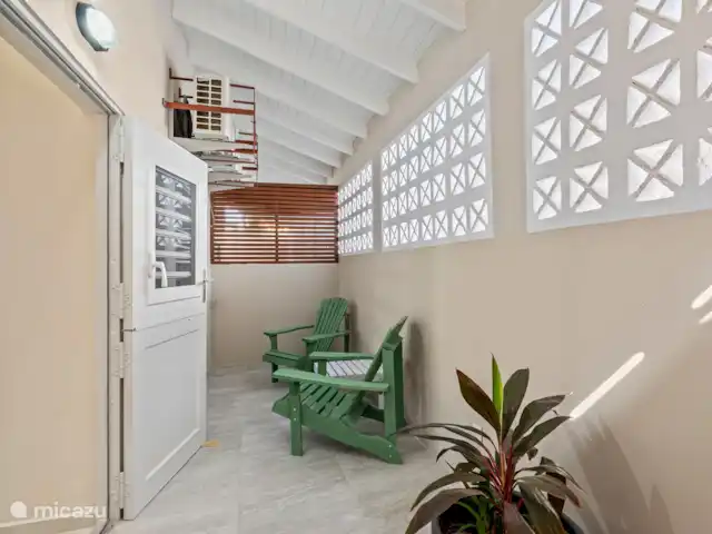 Bunita den Bario Apartments - B | Curaçao, Curaçao-Centre, Willemstad - maison de vacances Terrasse arrière avec sièges et machine à laver.