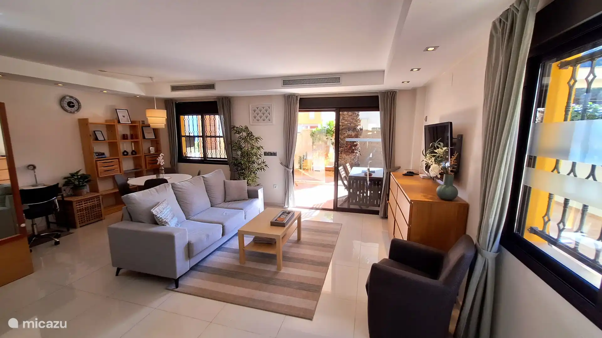 Ruime gezellige woonkamer met schuifpui naar het terras.