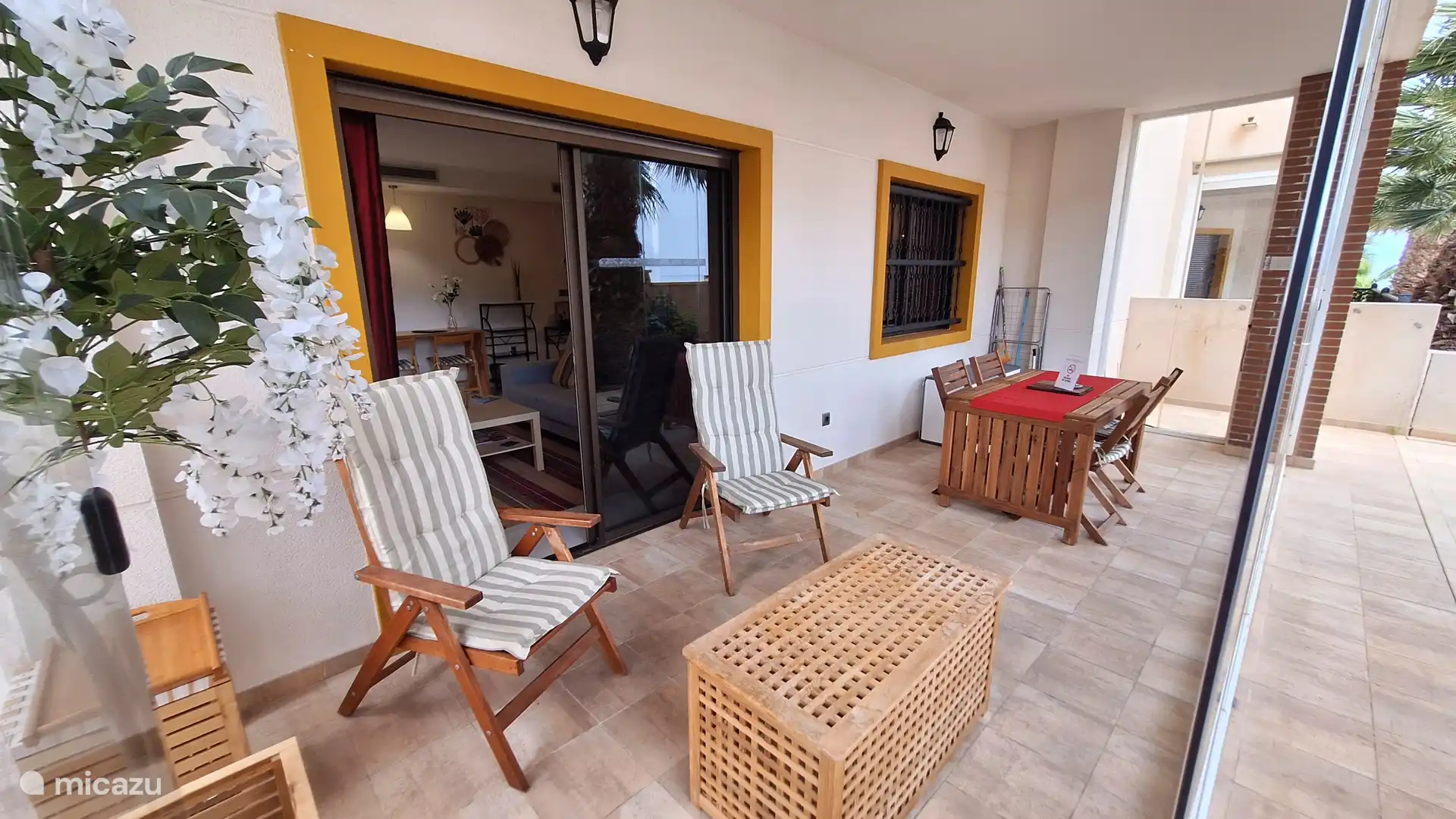 Entspannen Sie sich mit Blick auf die Palmen. Glaswand offen oder geschlossen. Das Essen kann im Innenbereich oder im Wintergarten gegessen werden. 