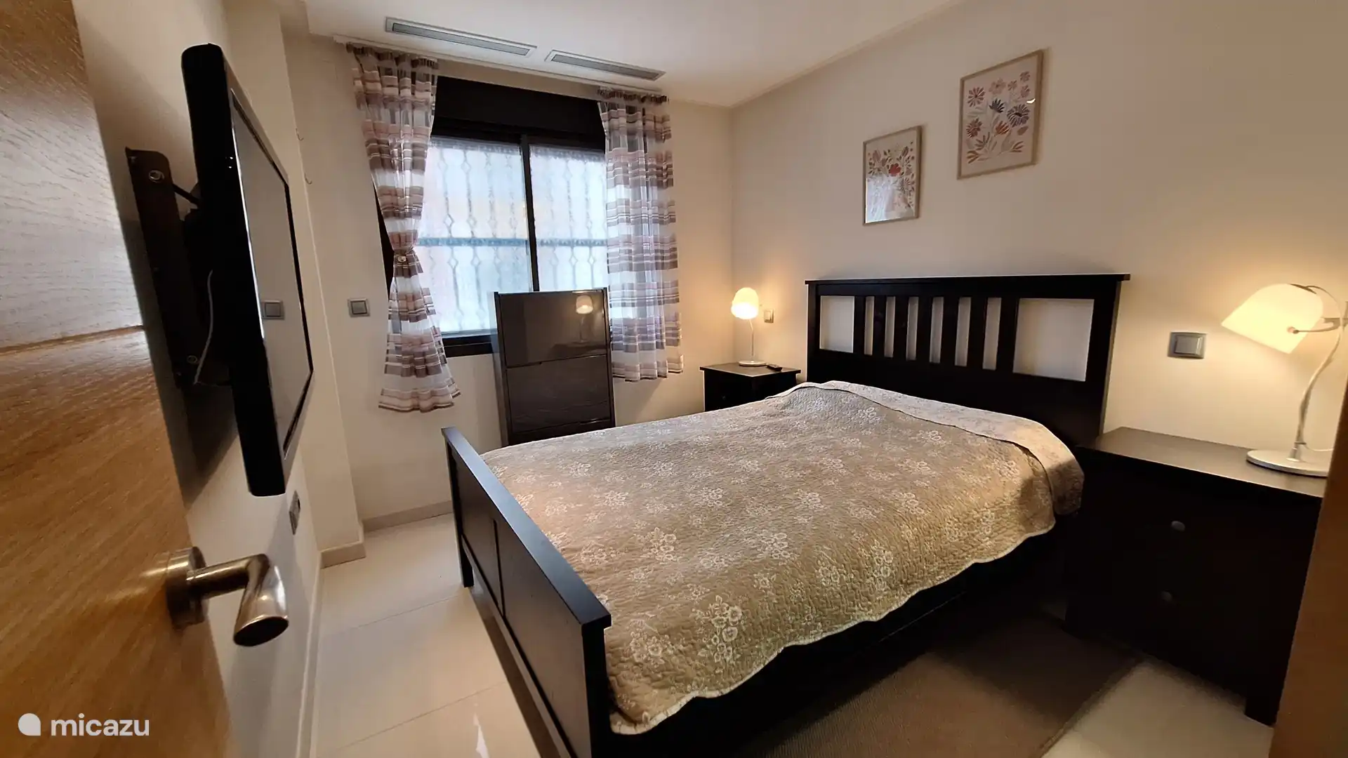 Schlafzimmer mit Doppelbett, Einbauschrank und TV