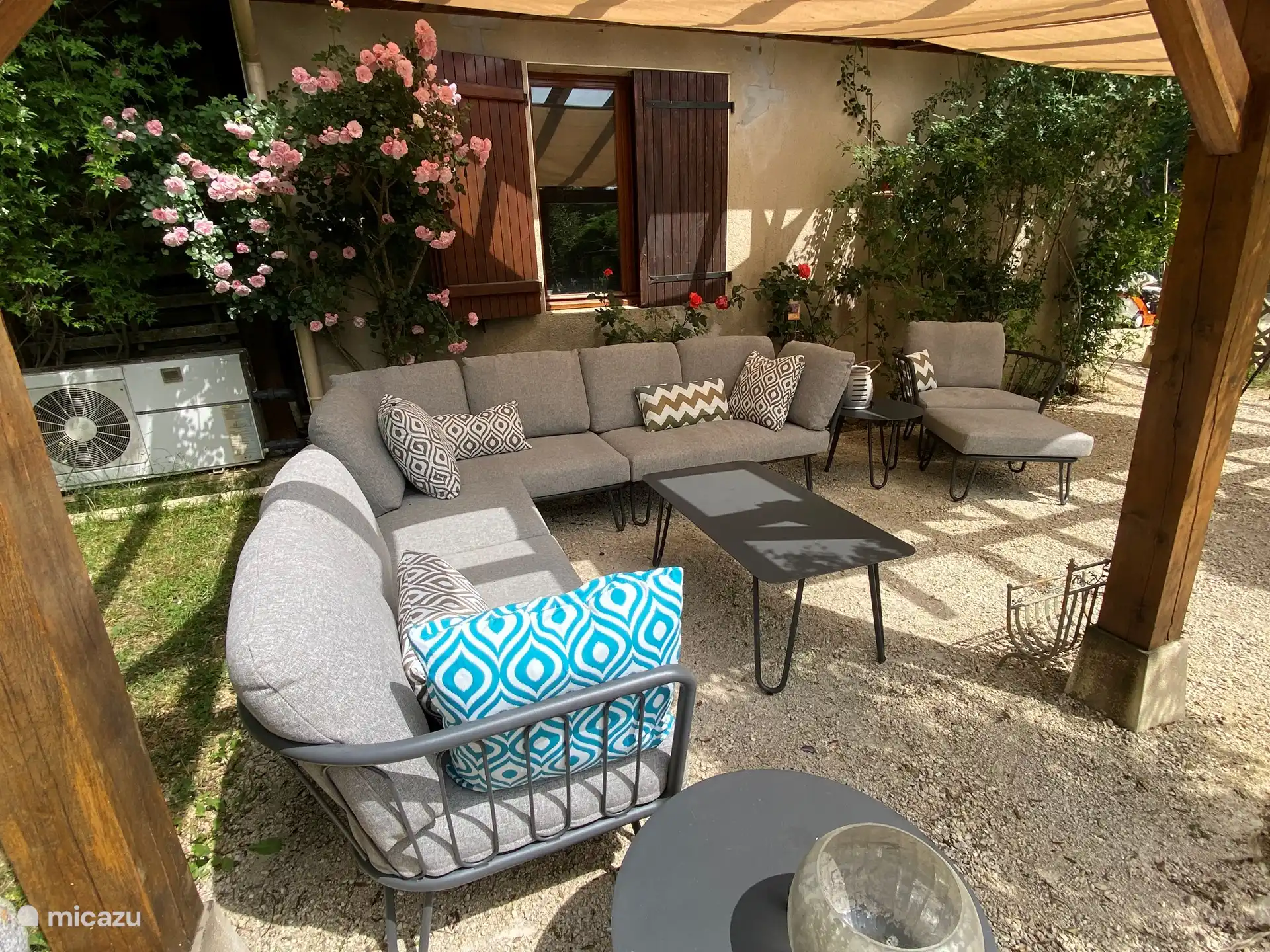 Lounge-Set neben dem Swimmingpool mit Sonnensegeln