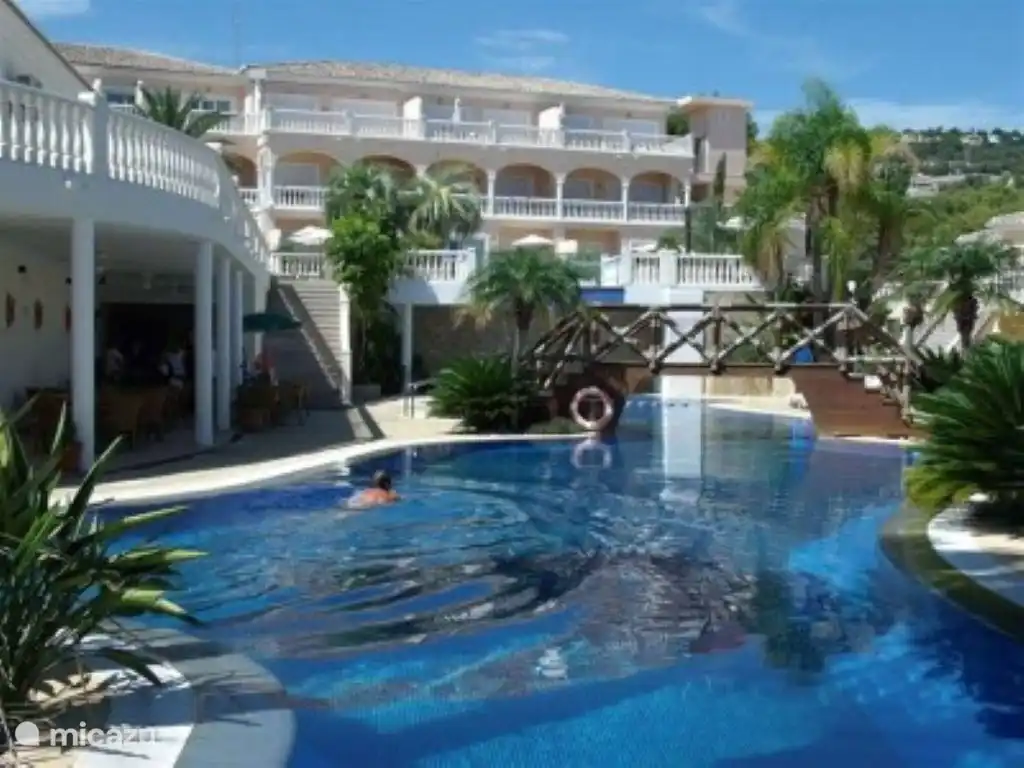 En regardant notre appartement en haut à droite et en montrant le snack-bar de la piscine à gauche.