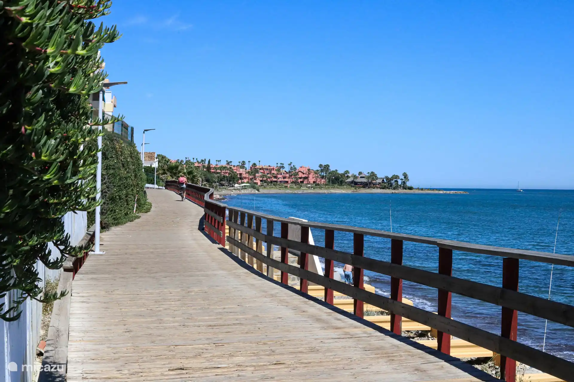 Wide promenade with a view of the village and the coast