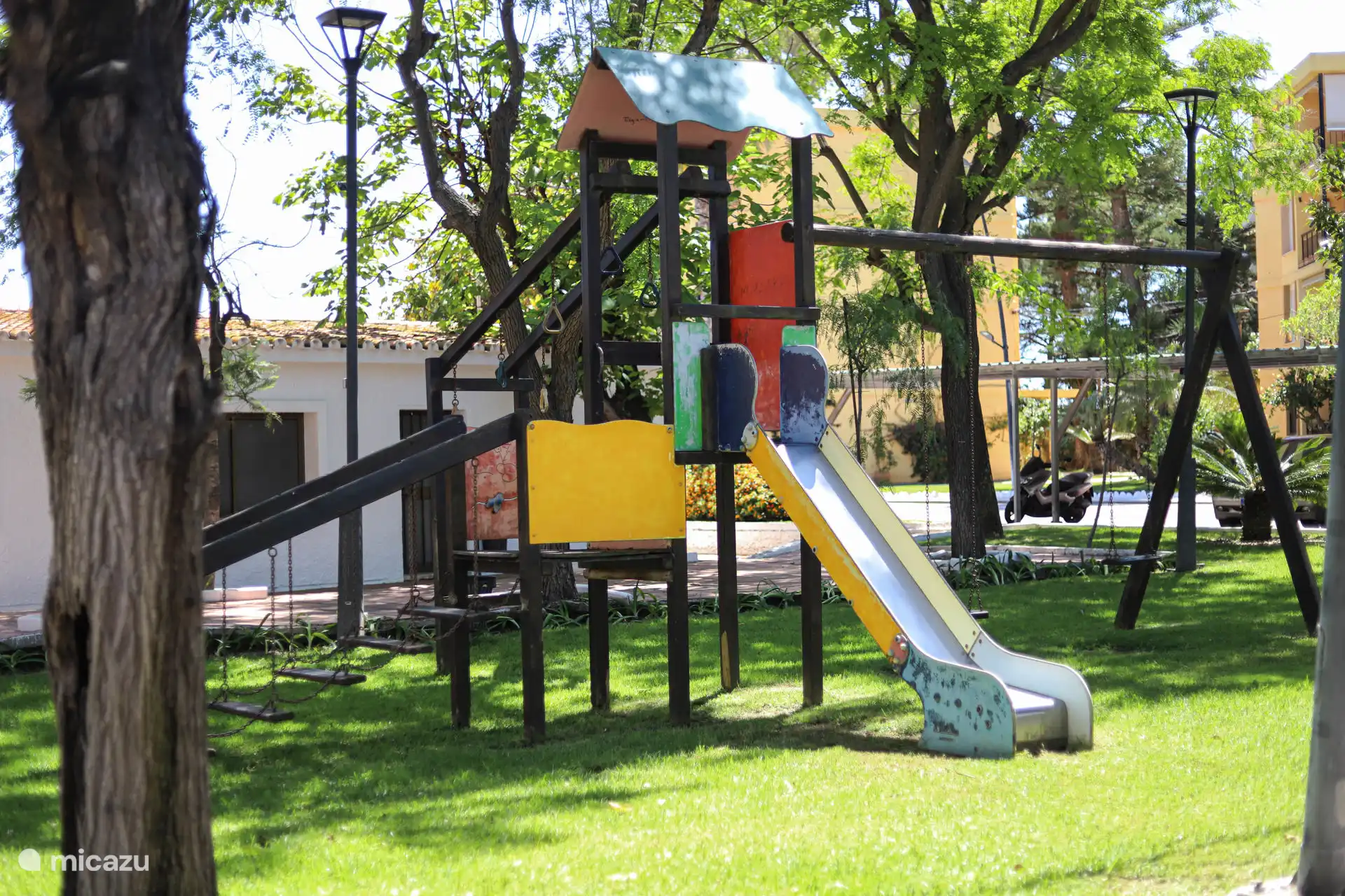 Playground with slide and swings under the trees