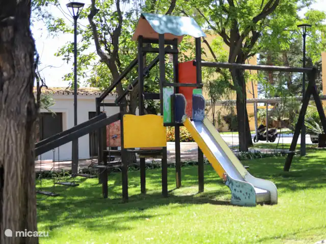 Location de Vacances Espagne, Costa del Sol, Estepona, appartement - Front de mer - Costa y Sol Aire de jeux avec toboggan et balançoires sous les arbres